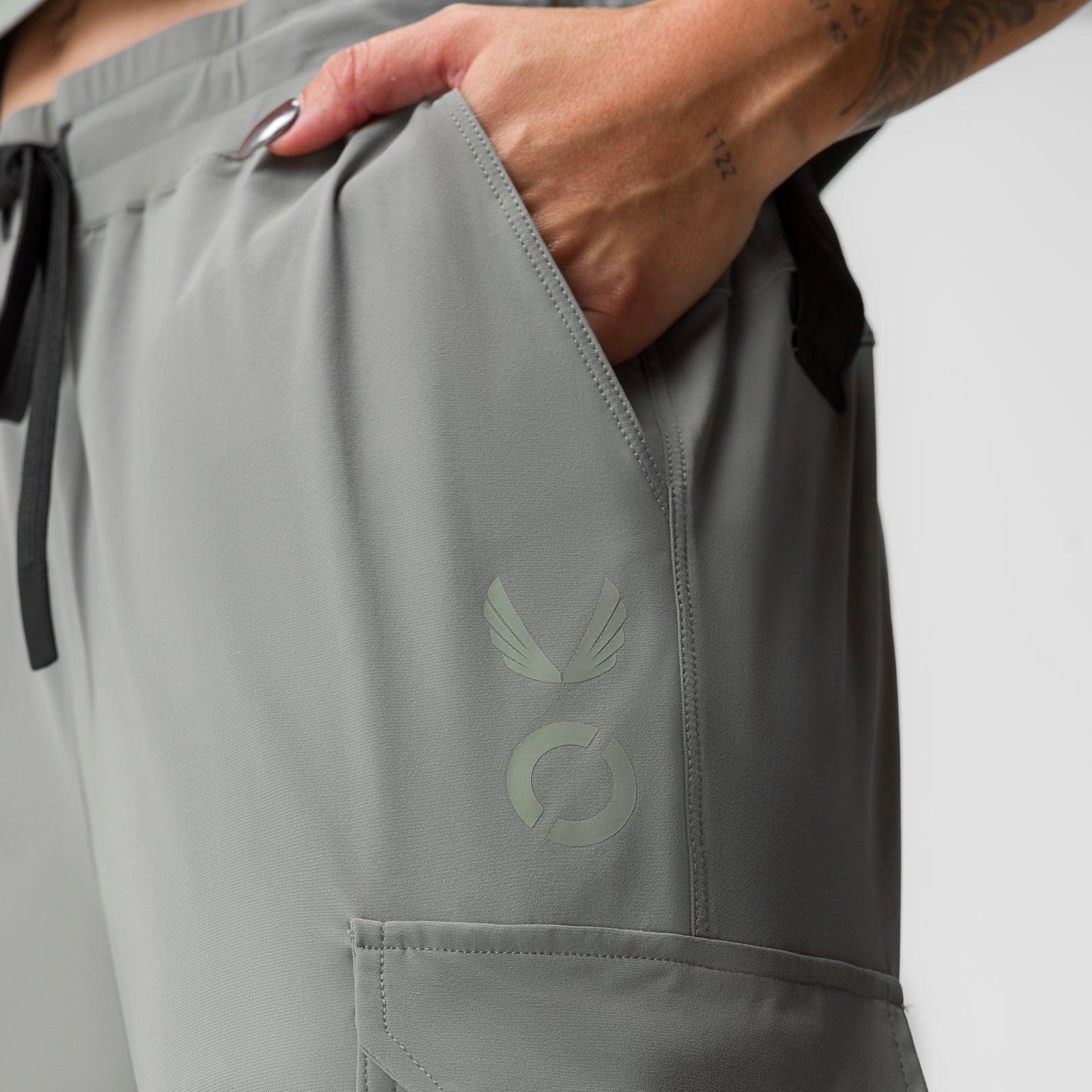 Sage Tetra-Lite® cargo jogger worn by model, showing side pocket and winged logo detail