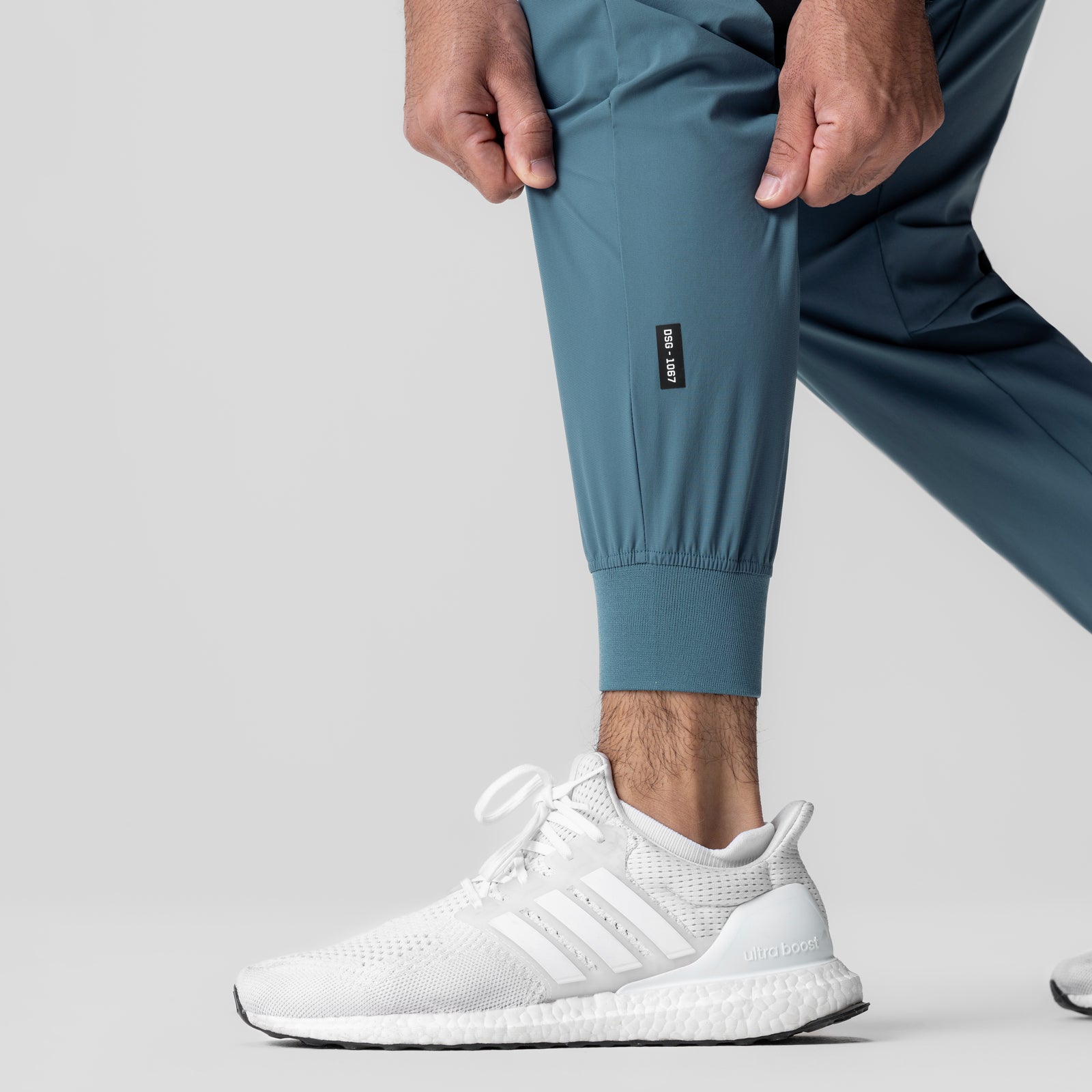 Tetra-Lite Cuffed Training Jogger in storm blue, worn with white sneakers, side view