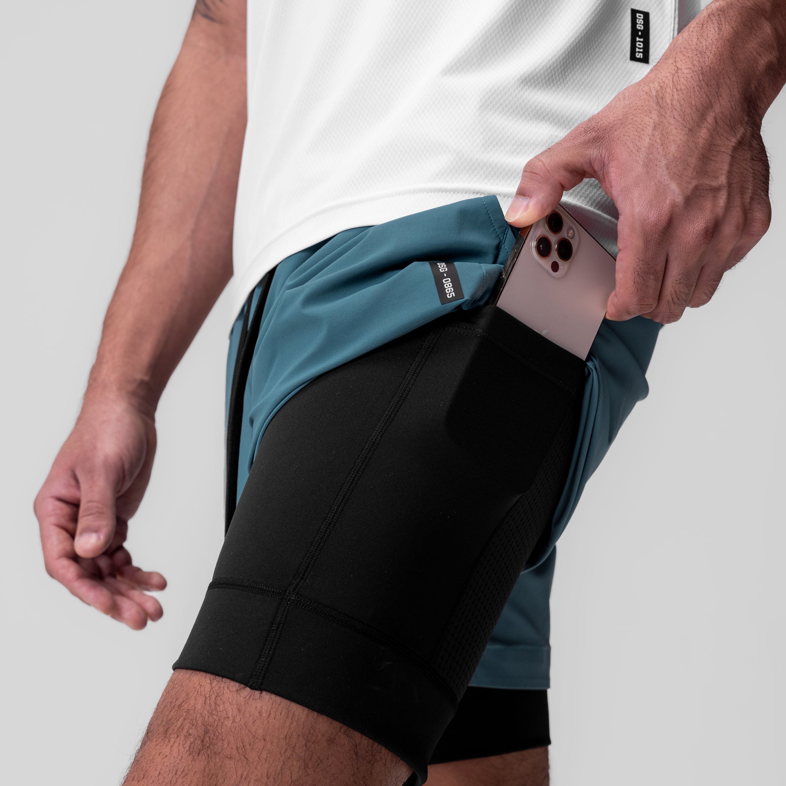 Tetra-Lite 5" Liner Short in Storm/Black being worn, model holding phone in side pocket