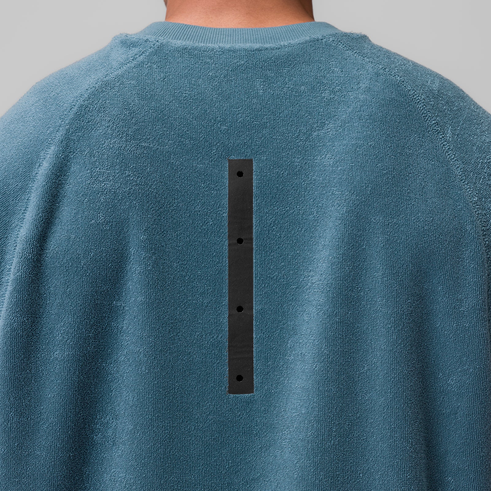 Towel Terry Cutoff in storm blue, back view with black button detail on model