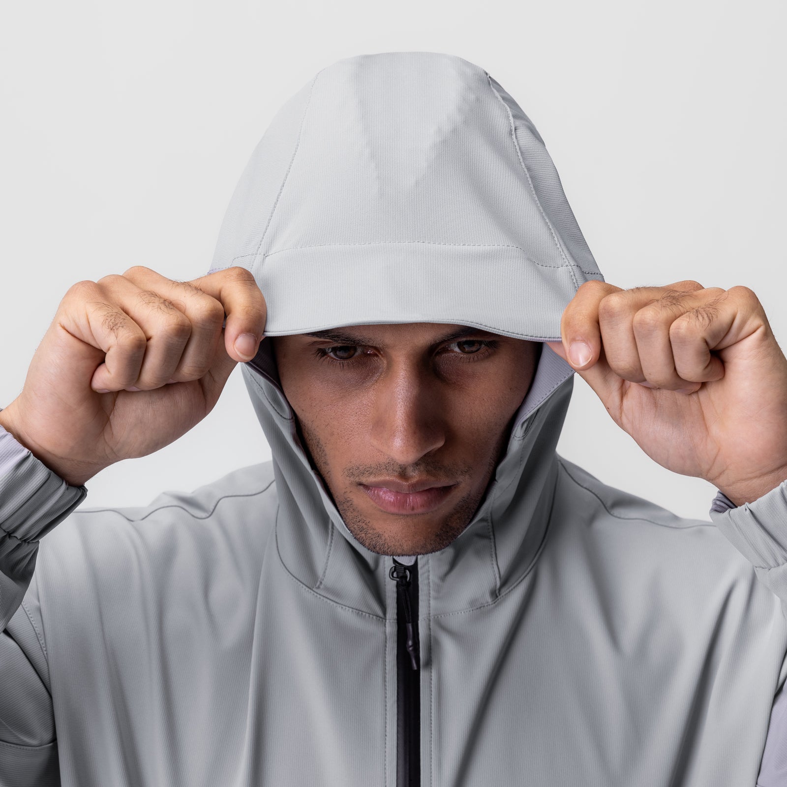 Weather-Ready Anorak Jacket in slate grey worn by model pulling hood down, front view
