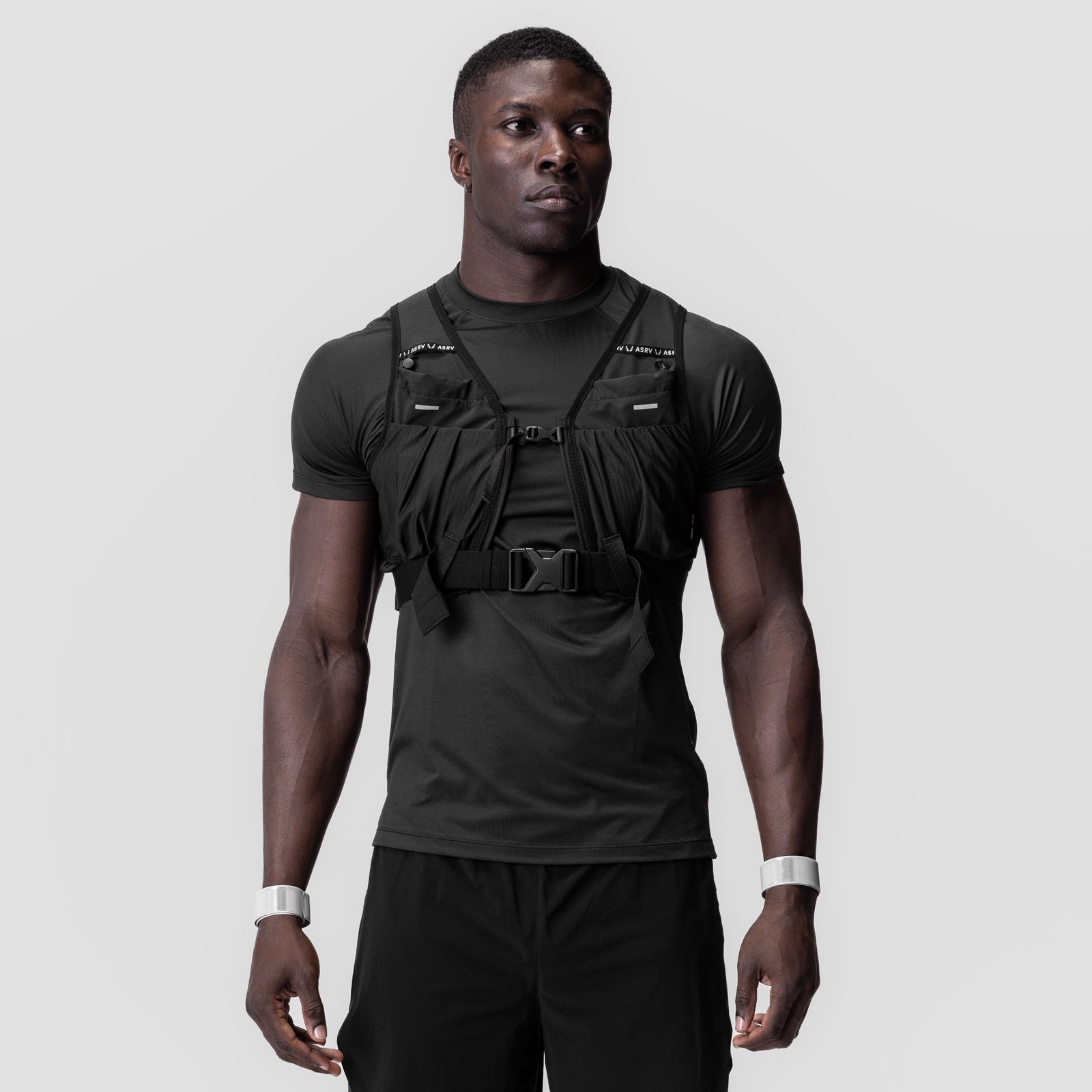 Black reflective snap band vest worn over black t-shirt, front view on model