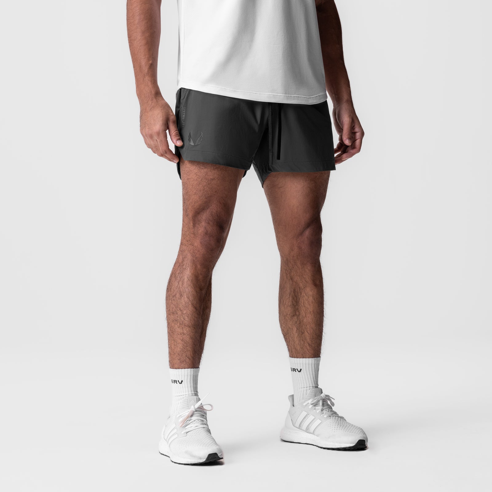 Tetra-Lite 5" Linerless Short in black, modeled on male figure with white socks and sneakers