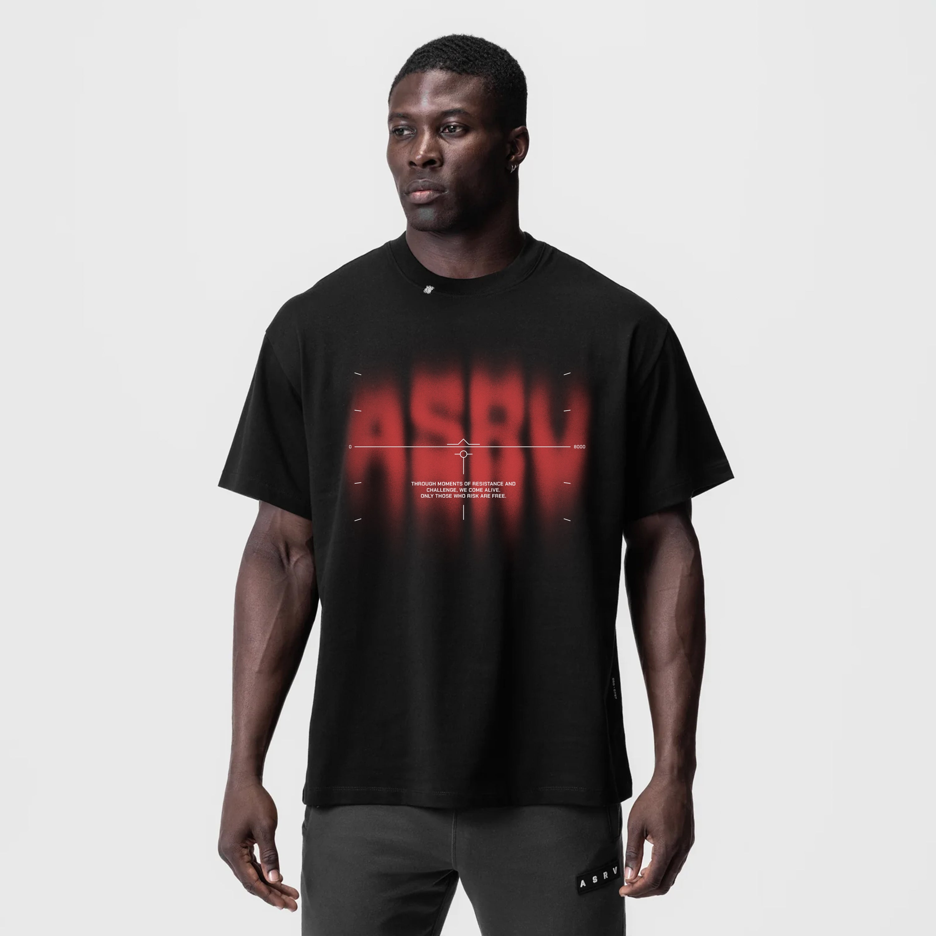 Black Tech Essential Relaxed Tee with red target graphic, worn by male model, front view