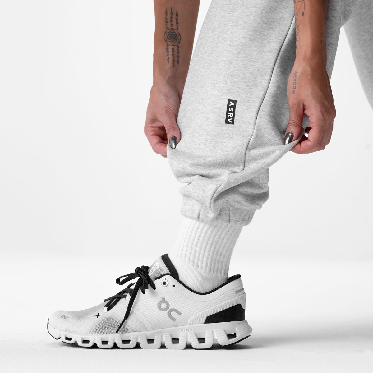 Heather grey oversized jogger worn with white socks and running shoe, side view