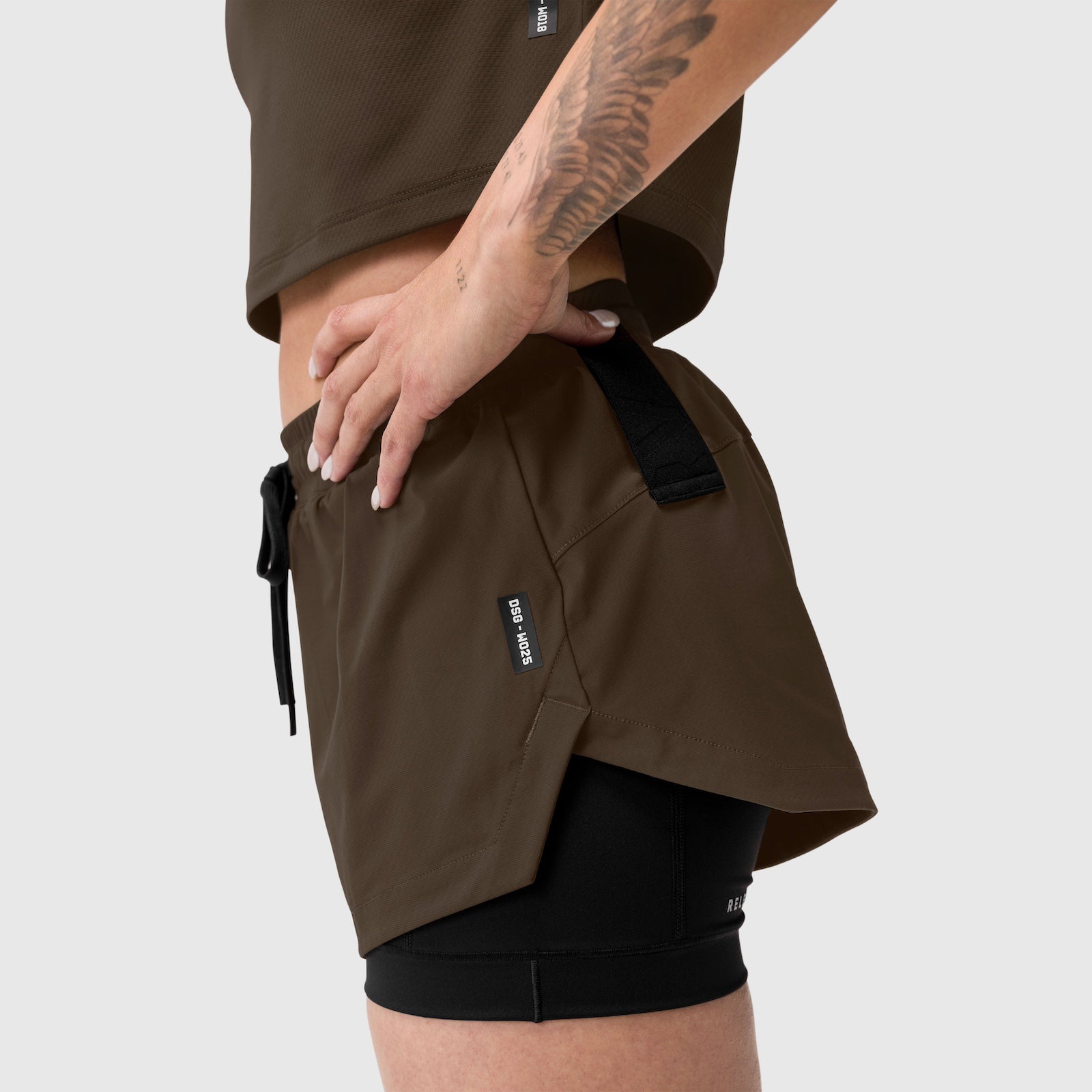 Tetra-Lite Liner Short in Dark Earth worn by model, side view showing layering with black shorts