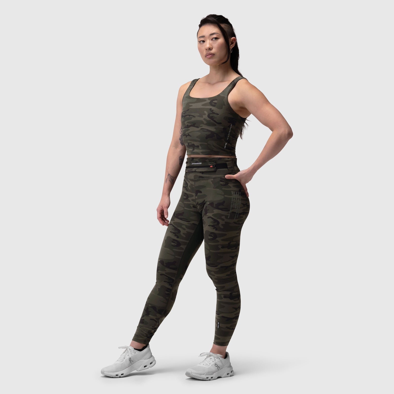W030 LYCRA® 3-in-1 Legging in dark camo, worn with matching crop top and white sneakers