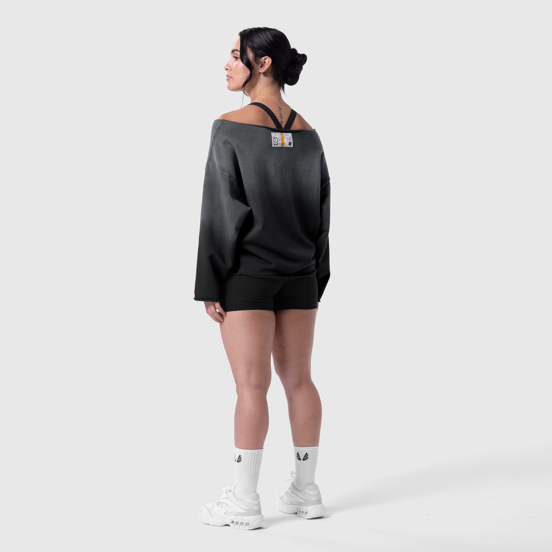 Raw Hem Oversized Crewneck in black sun fade, worn by model standing in profile view