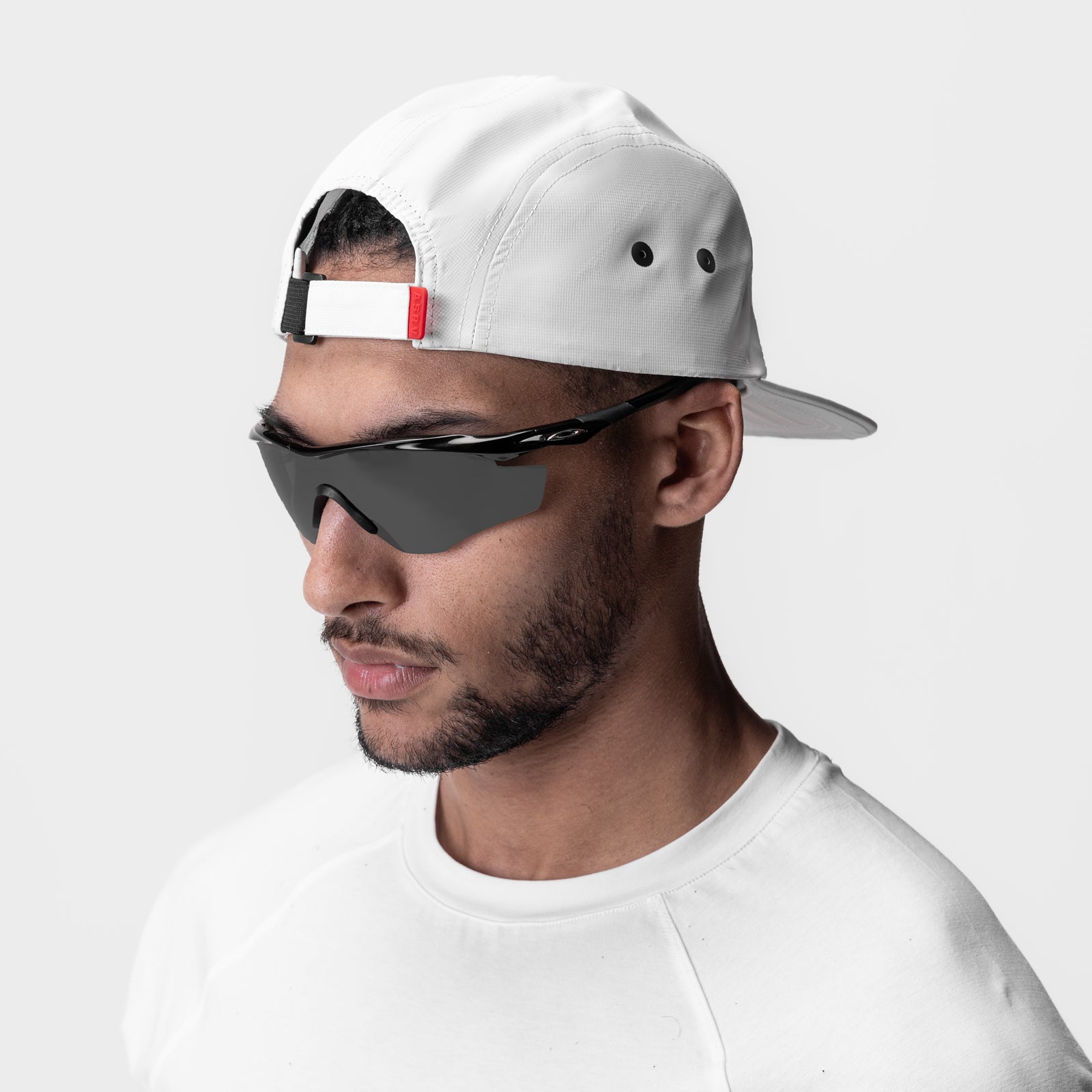 White 5-Panel Run Cap worn by model with sunglasses, side profile view