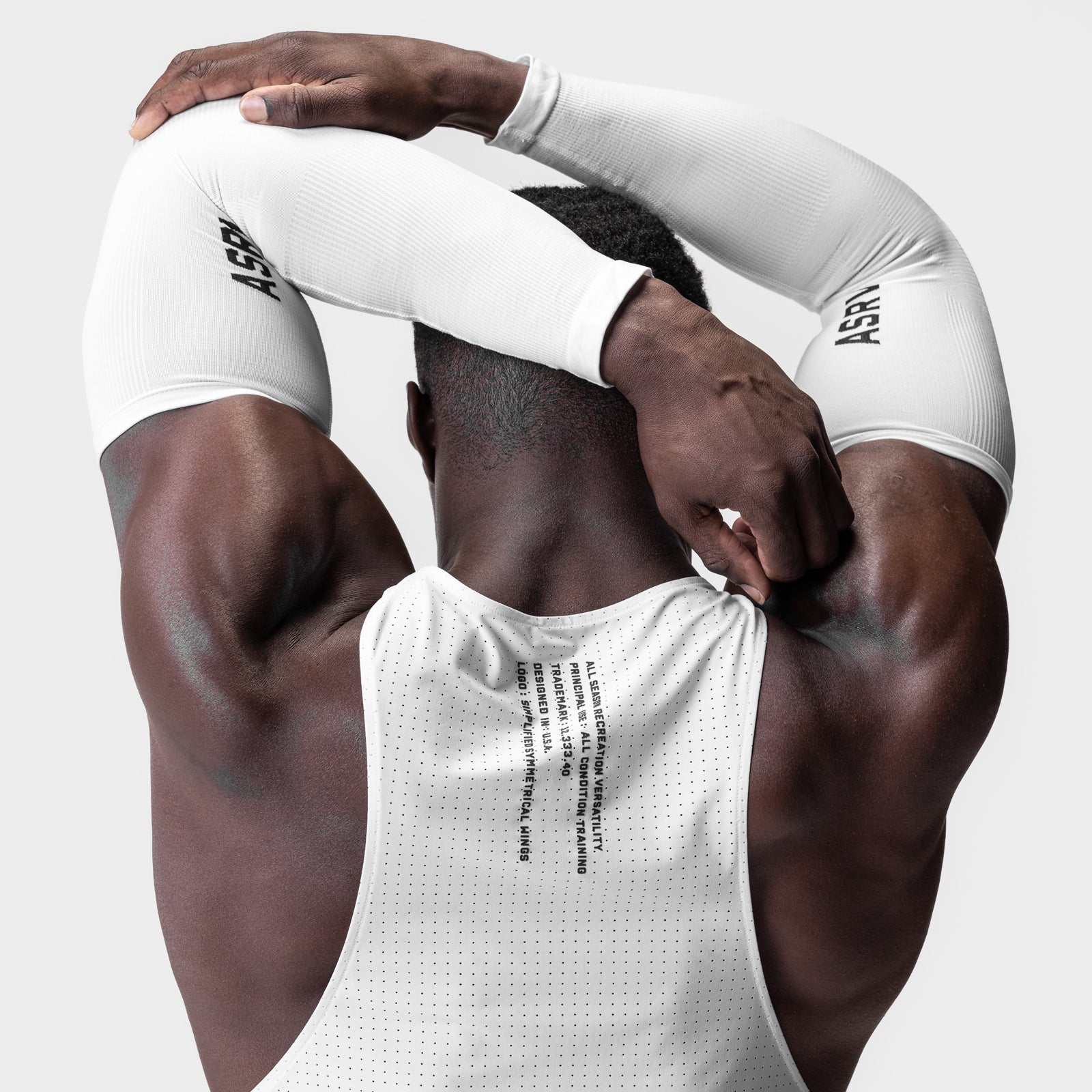 White body-mapped arm sleeve worn by model, overhead pose showing muscular definition