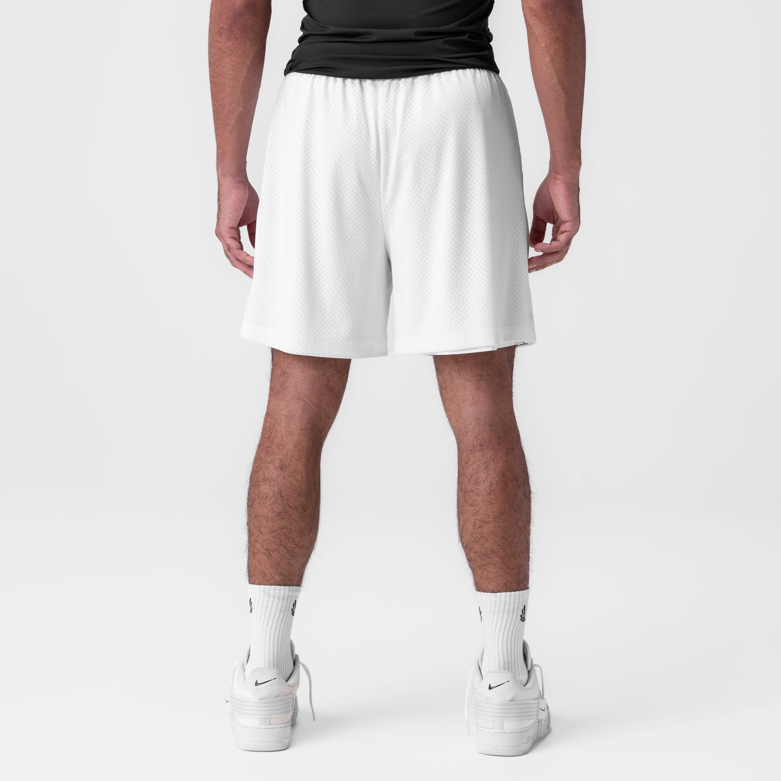 Reversible 2-in-1 shorts in white, back view on model wearing black top and white socks