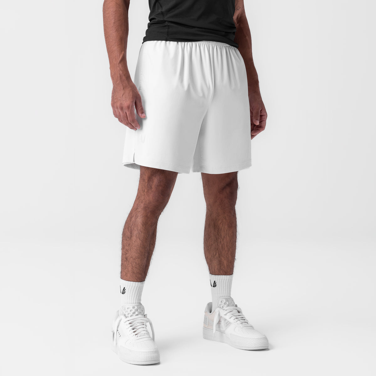 Reversible 2-in-1 shorts in white, modeled on male figure with white sneakers and socks