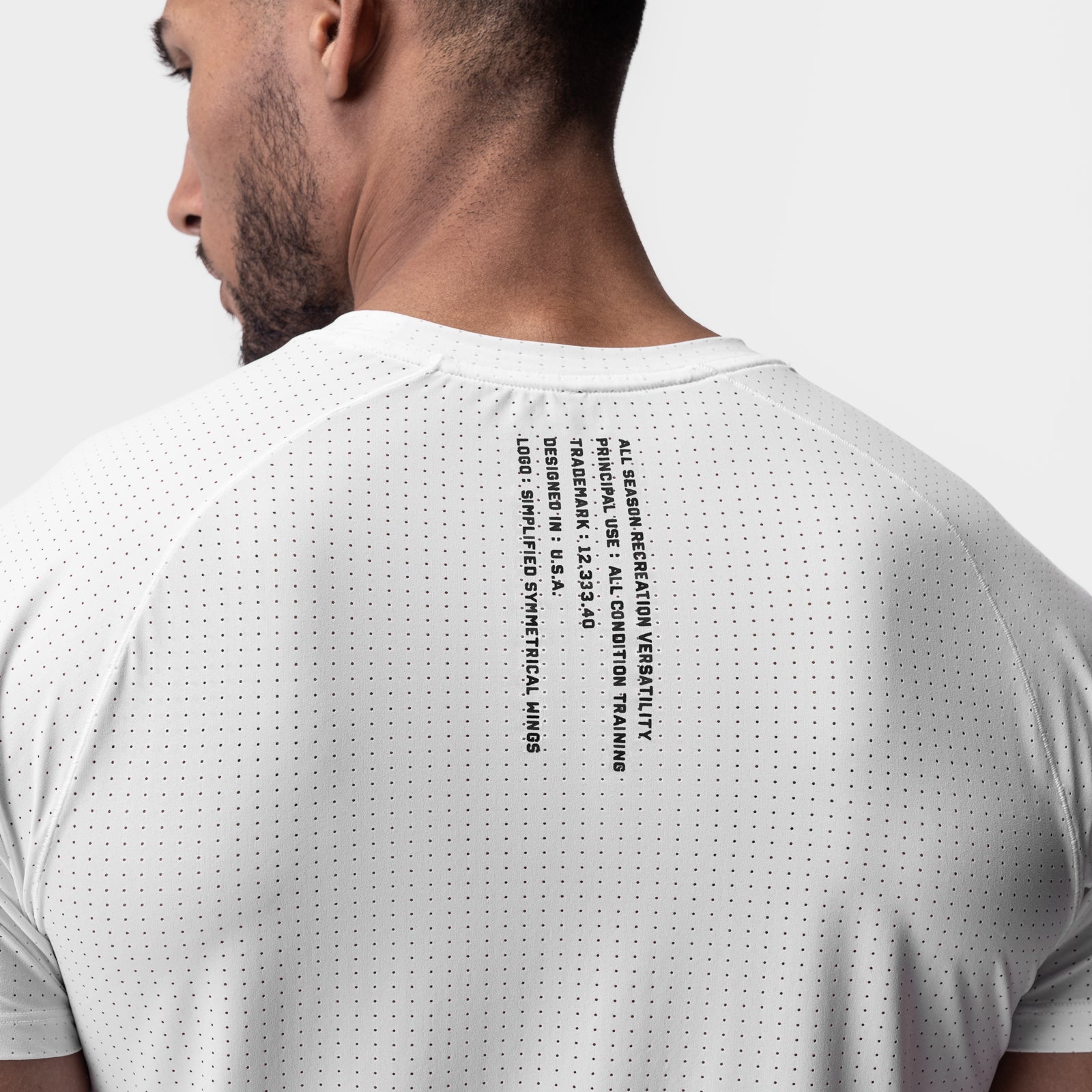 White Laser-Vent Established Tee worn by model, back view showing perforated fabric and text design