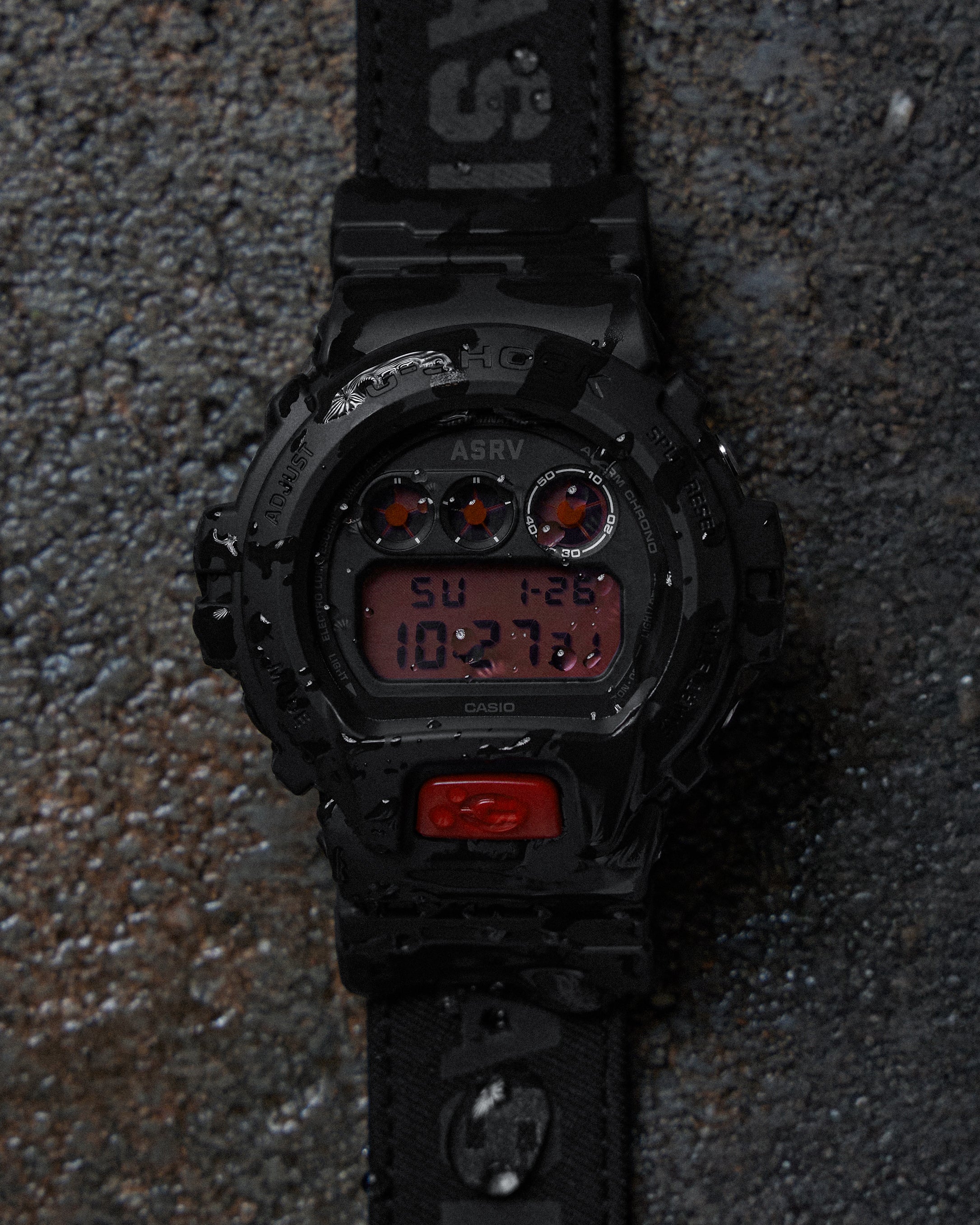 ASRV x G-SHOCK DW6900 digital watch in black, laid flat on concrete surface