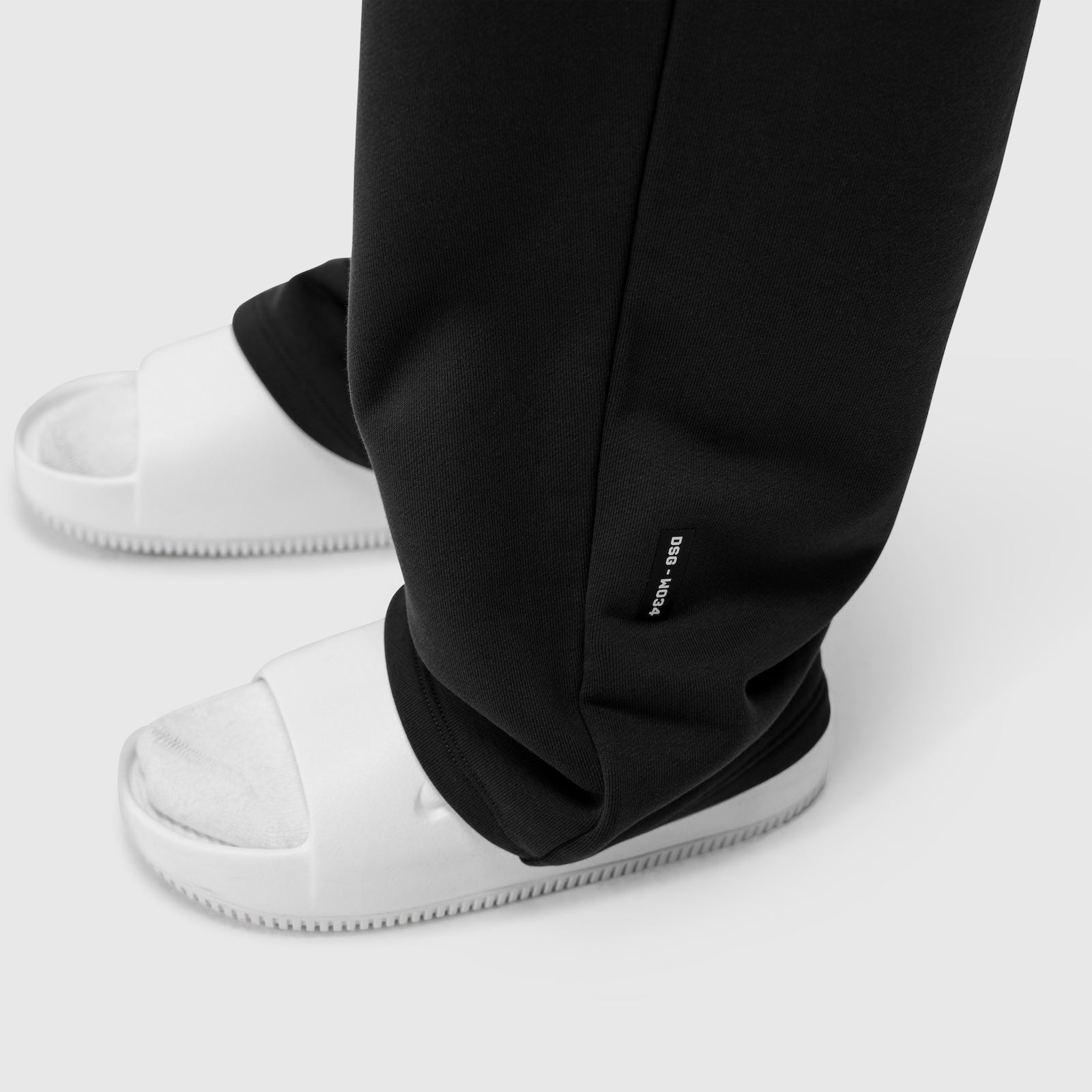 Black Sorona® Terry straight leg sweats worn with white sneakers, ankle detail view