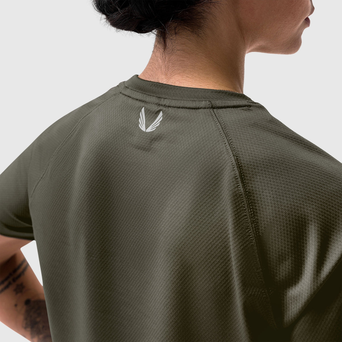 AeroSilver® Cropped Tee in olive, worn by model from back view showing feather logo