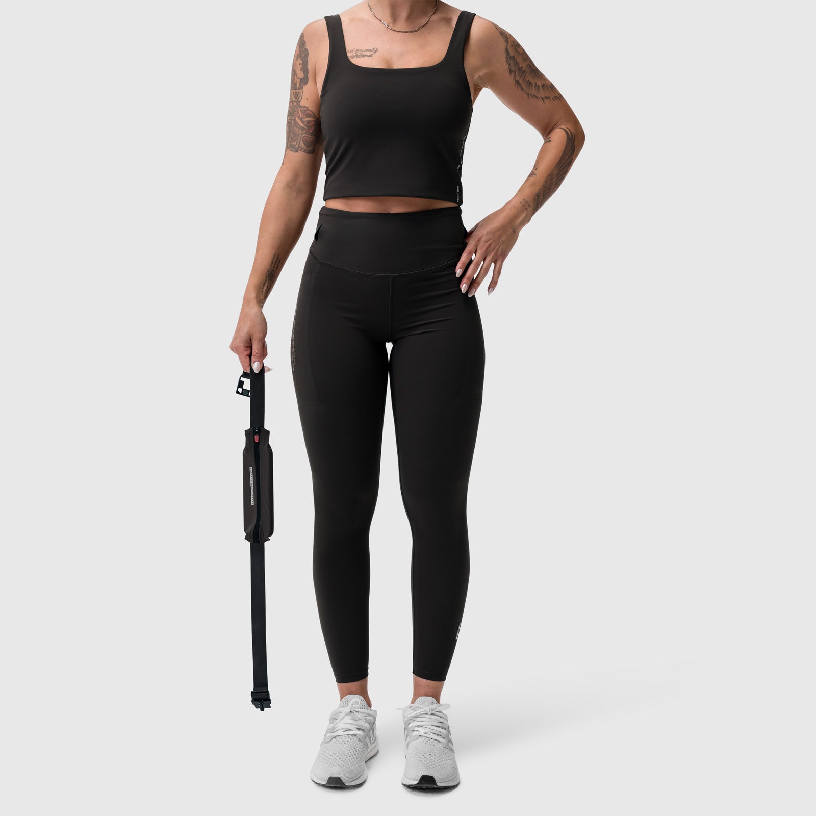 LYCRA® 3-in-1 Legging in black, worn with crop tank top and white sneakers, front view