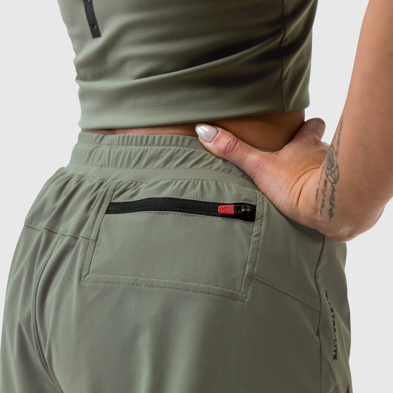 Tetra-Lite Liner Short in sage worn by model, back pocket detail with zipper closeup
