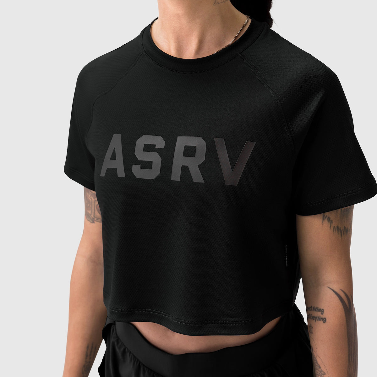 Black ASRV cropped tee worn by model, front view with logo