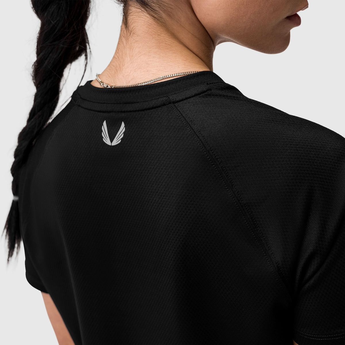 Black AeroSilver Cropped Tee worn by model, back view with logo detail