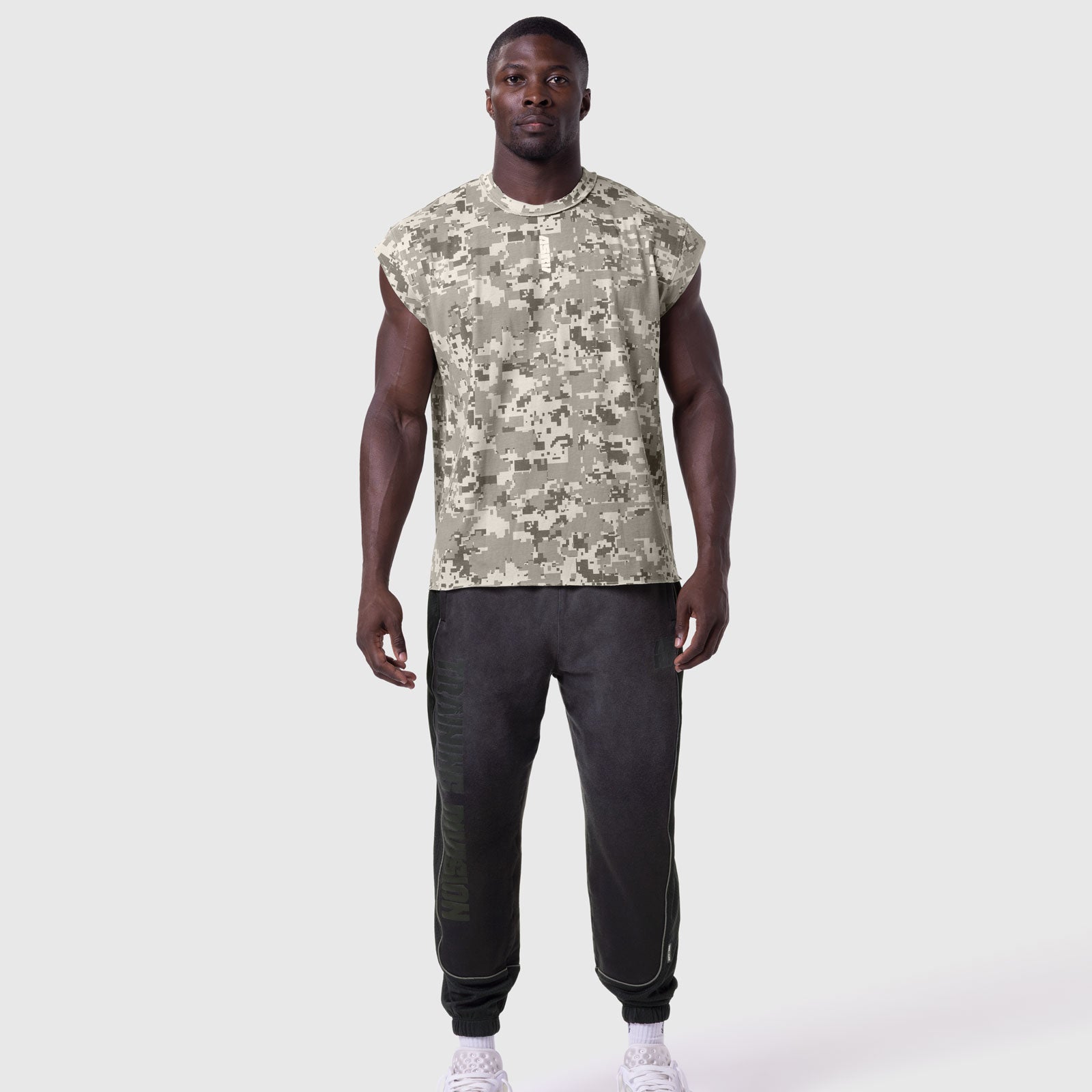 Tech Essential Cap Shoulder Cutoff in digital camo, worn with black joggers, front view
