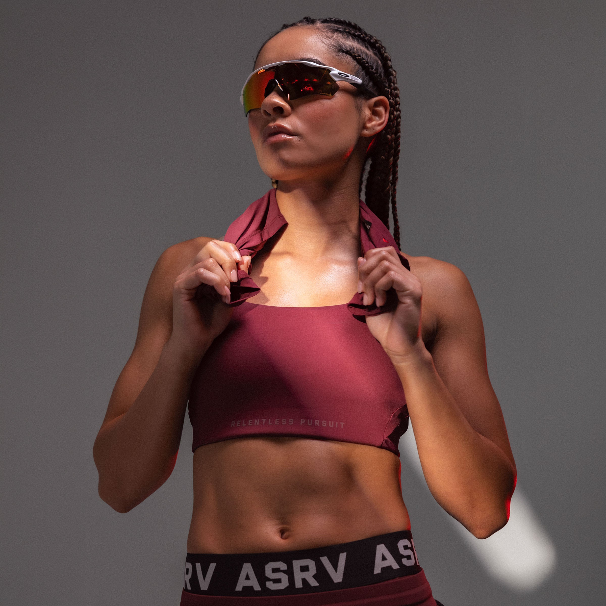 Crimson Lycra Hybrid Sports Bra worn by model with maroon jacket, front view