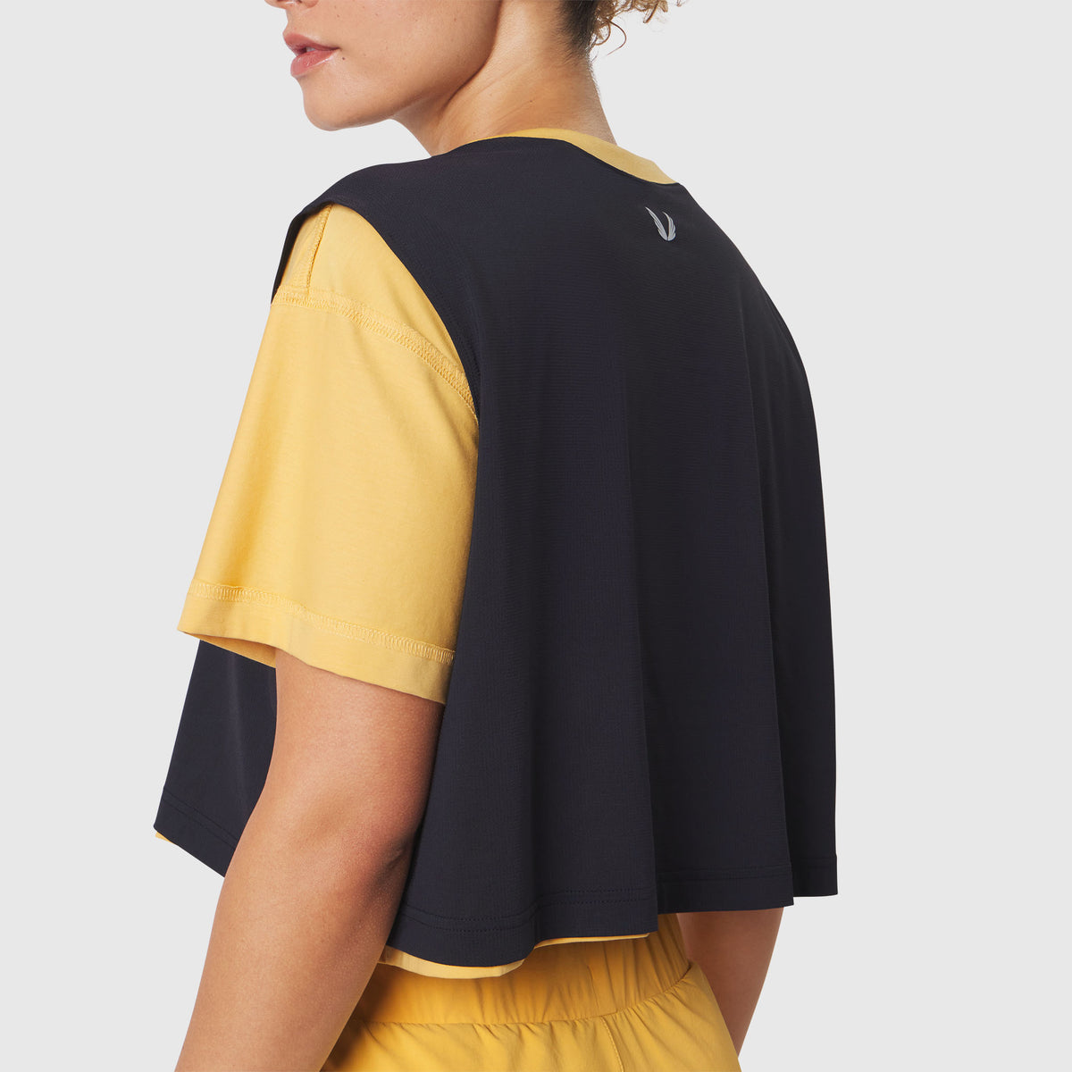 Reversible crop tee in amber and black, back view on model