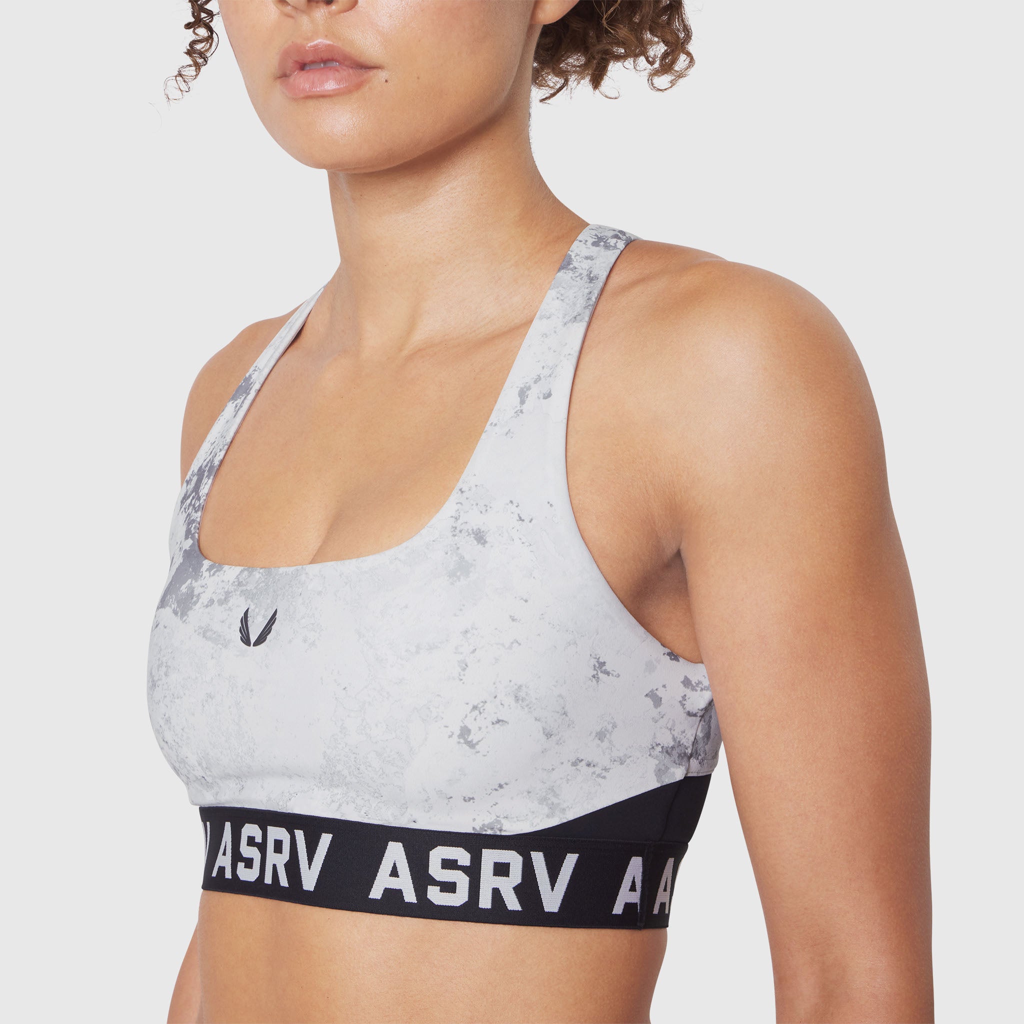 W083 LYCRA® ADAPTIV Racerback Sports Bra in Sedona Snow Camo, worn by model