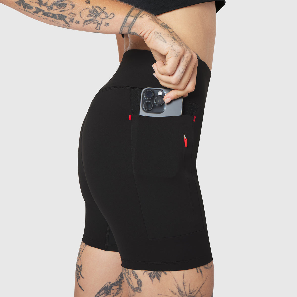 W099 LYCRA® ADAPTIV Hybrid Bike Short in black, worn by model holding phone in pocket