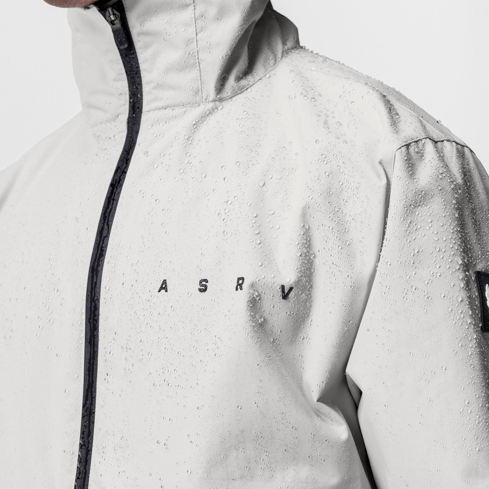 Hipora® Tech Parka in stone worn by model, front view with water droplets on fabric
