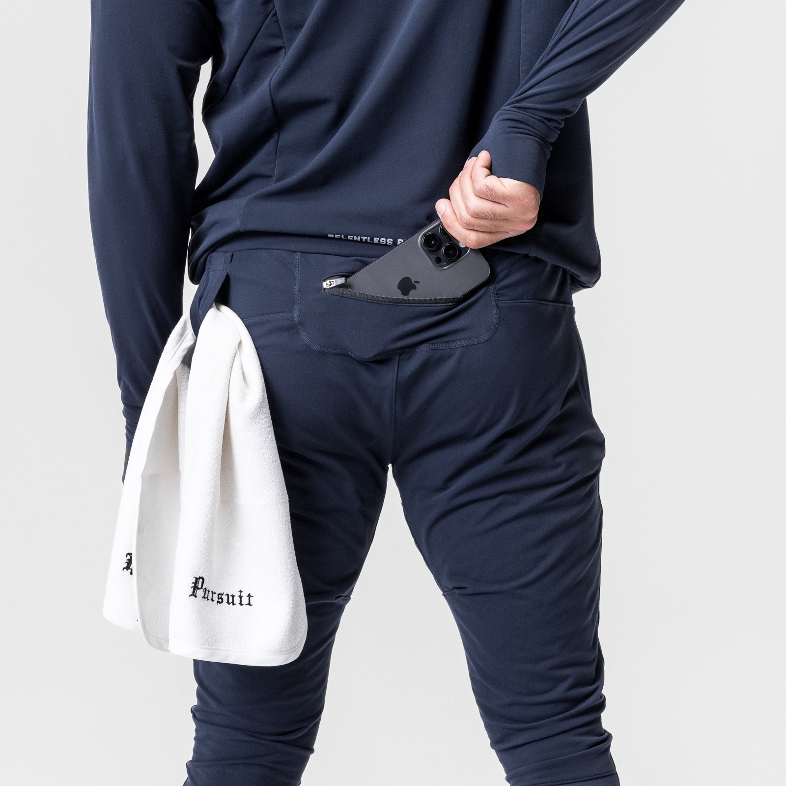 Thermal Hybrid Jogger in navy worn by model holding phone and white Pursuit towel