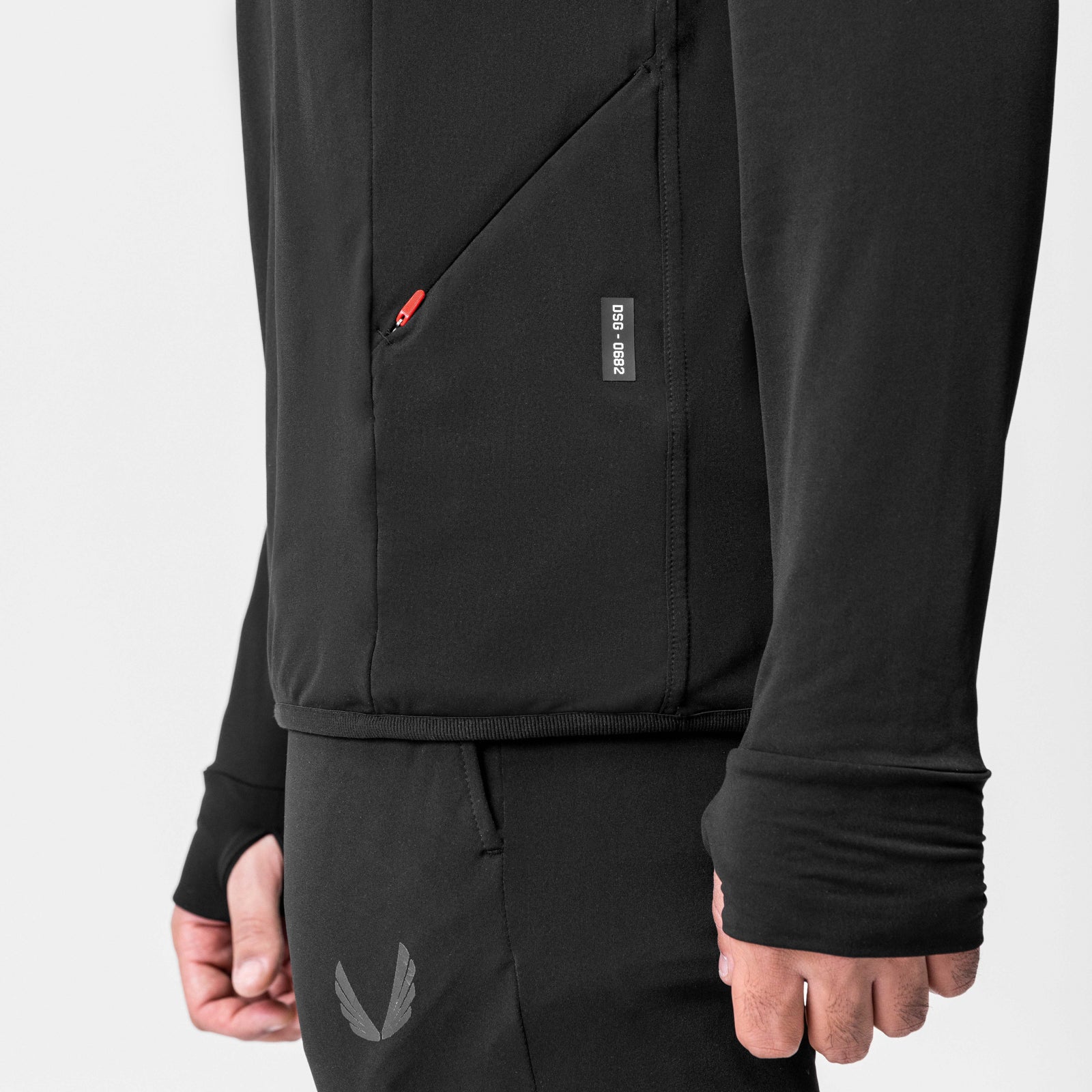 Black training hoodie worn by model, showing front zip closure and sleeve detail
