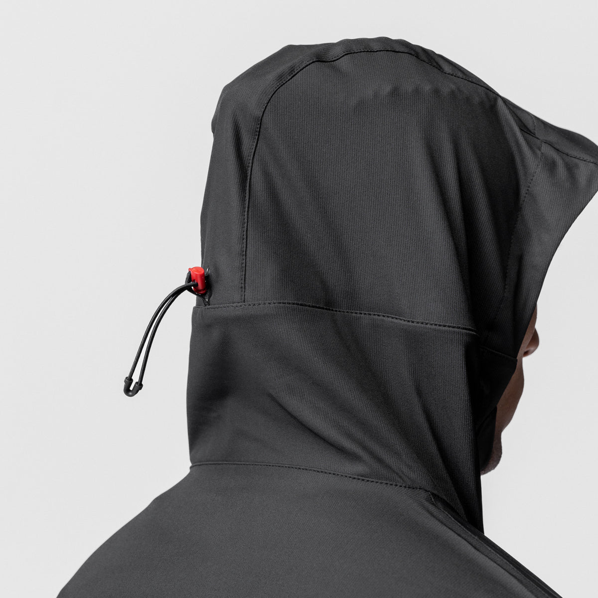 Black weather-ready anorak jacket on model, rear hood view