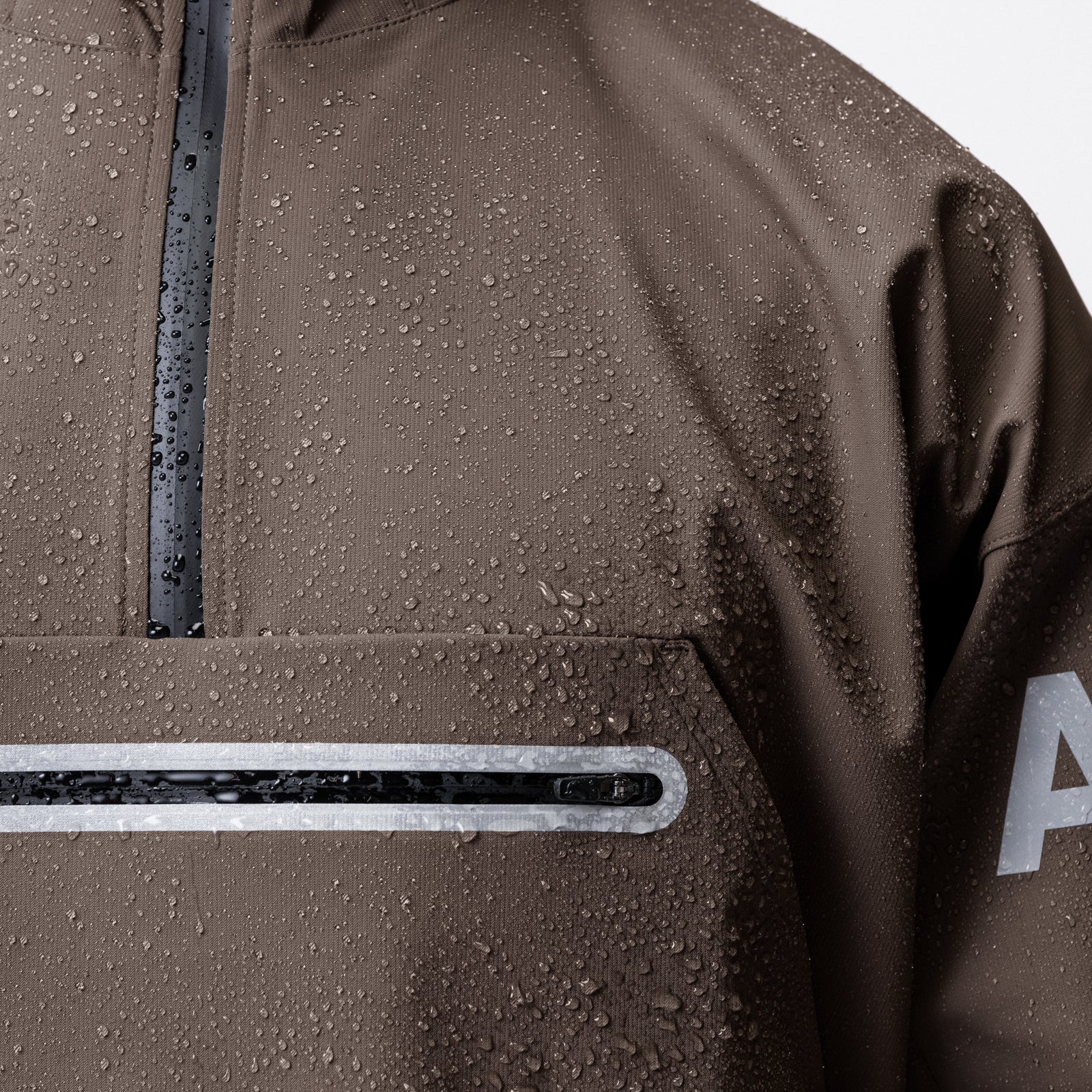 Weather-Ready Anorak Jacket in Deep Taupe, detail shot showing water-beading fabric and reflective stripe