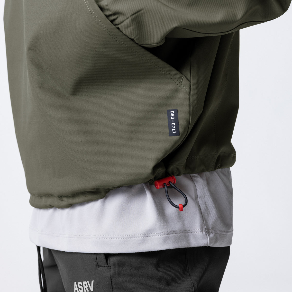 Weather-Ready Anorak Jacket in olive, worn with white and black layers, detail shot