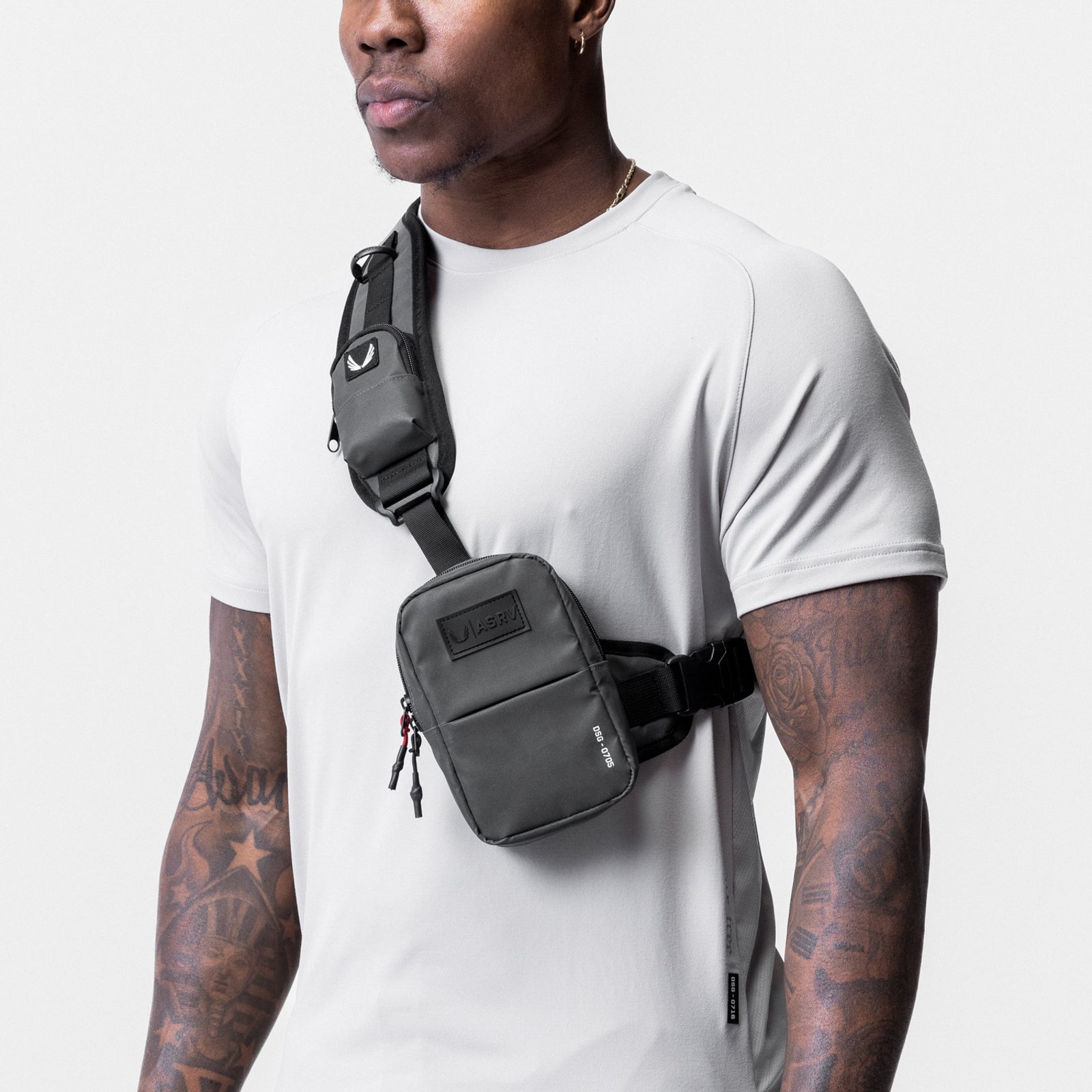 Reflective Holster Sling Bag in black worn across model's chest with white t-shirt