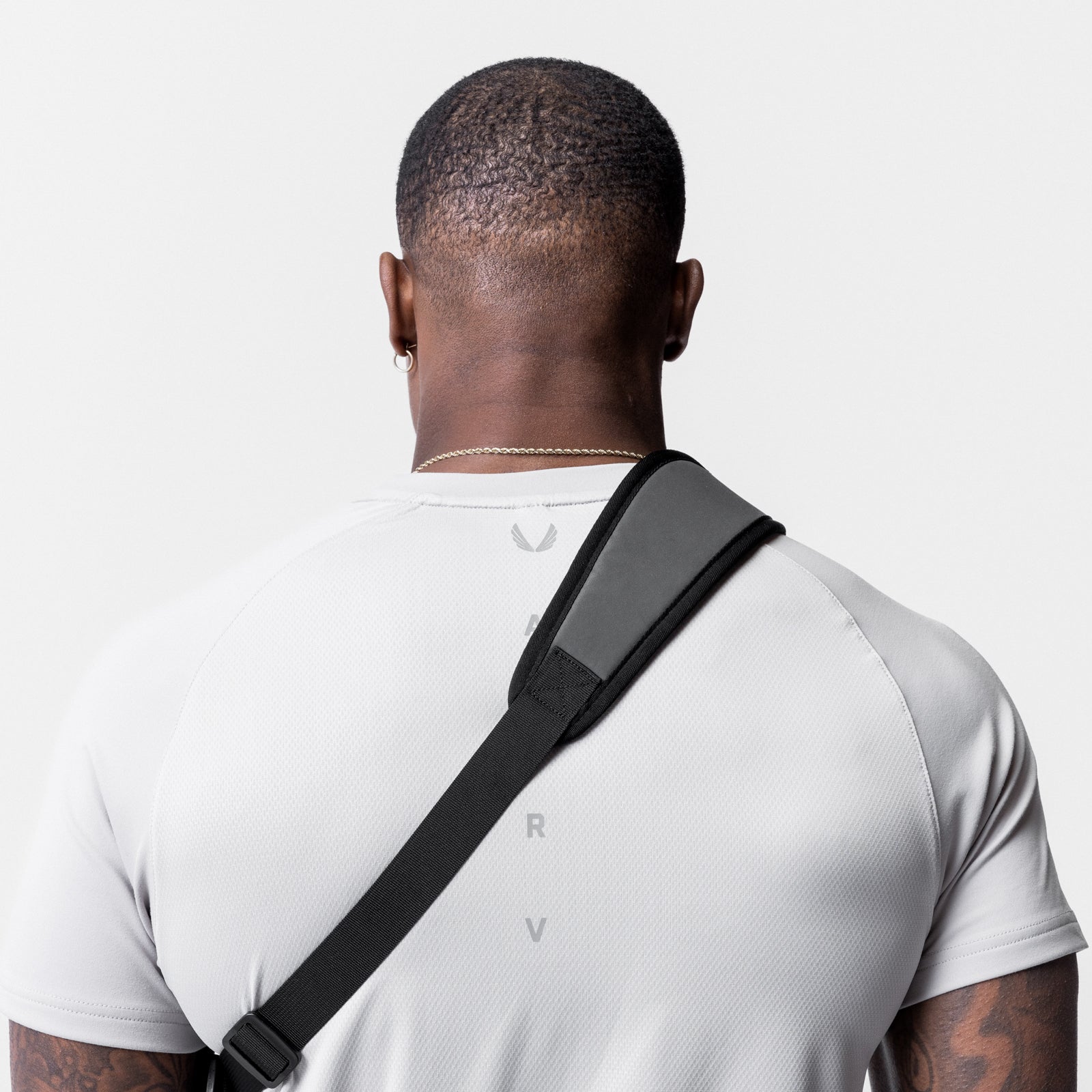 Reflective Holster Sling Bag in black, worn across model's chest, back view
