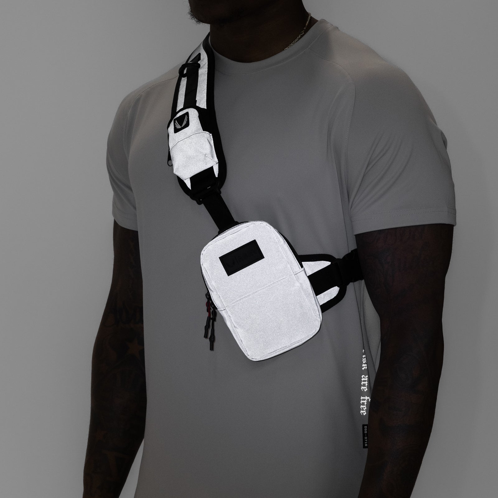 Reflective Holster Sling Bag in white, worn across chest on model in grey tee