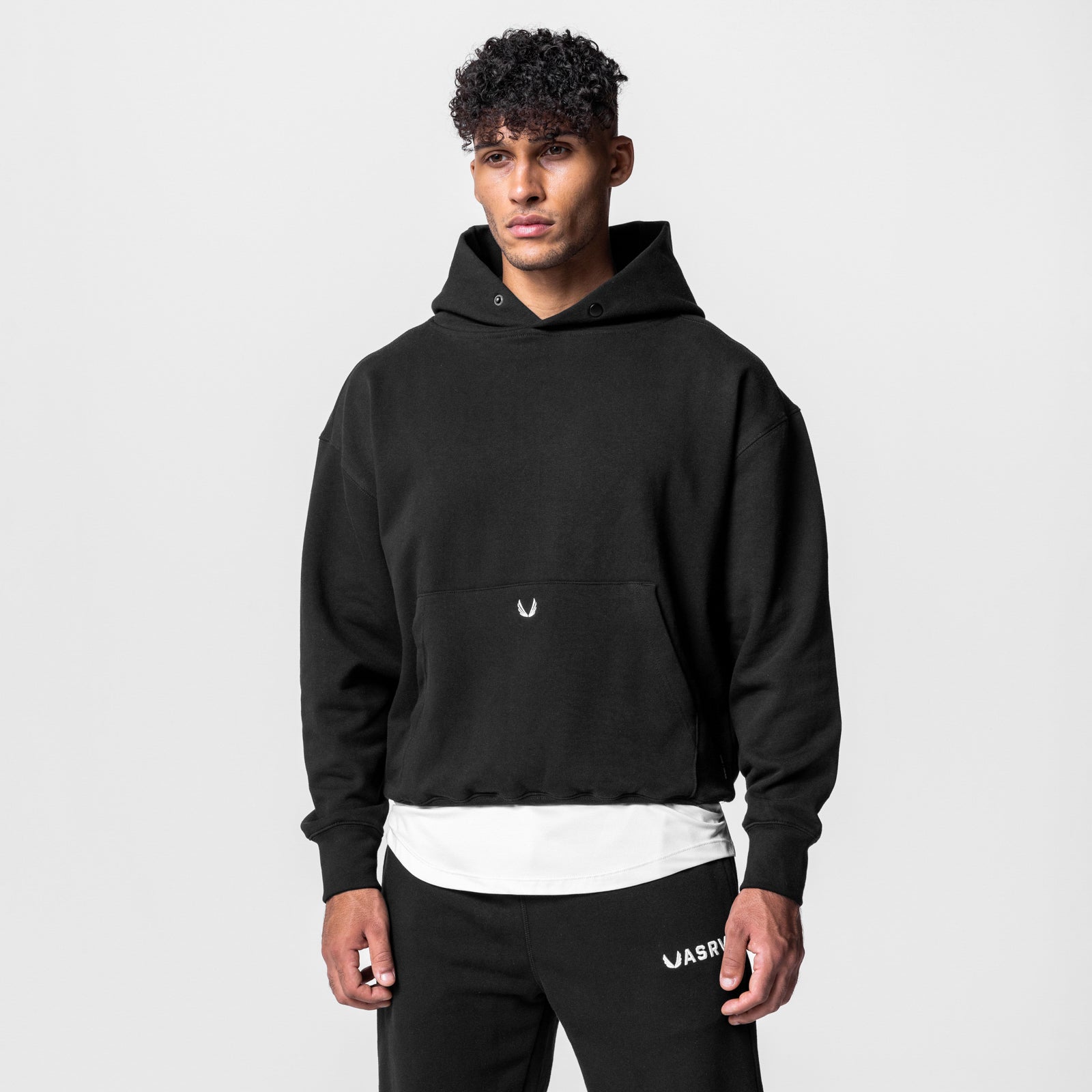 Black Tech-Terry hoodie worn by model with white undershirt, front view