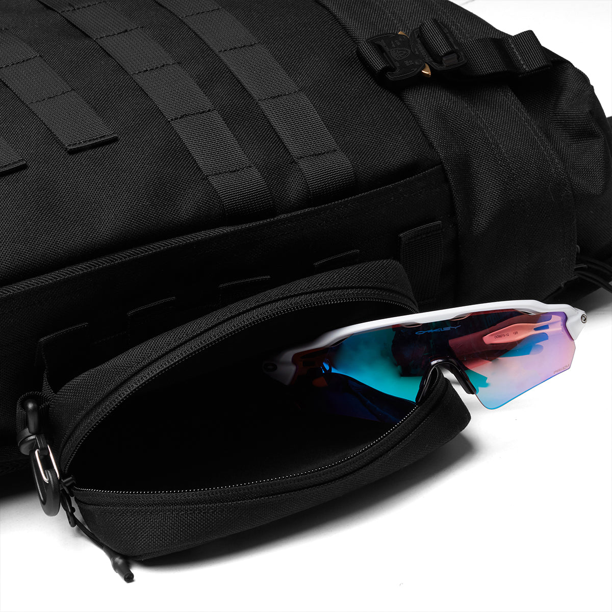 Flatlay of 0275 Modular Everyday Pack in black with sunglasses, open compartment view