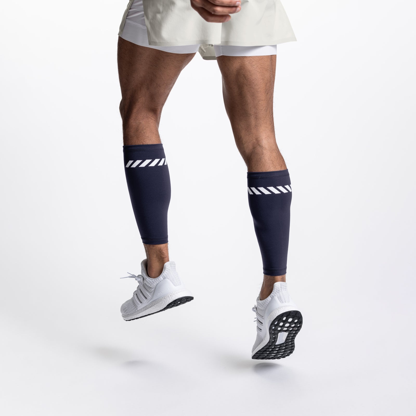 WarpFlexx® Calf Sleeve in navy with white stripes, worn while running