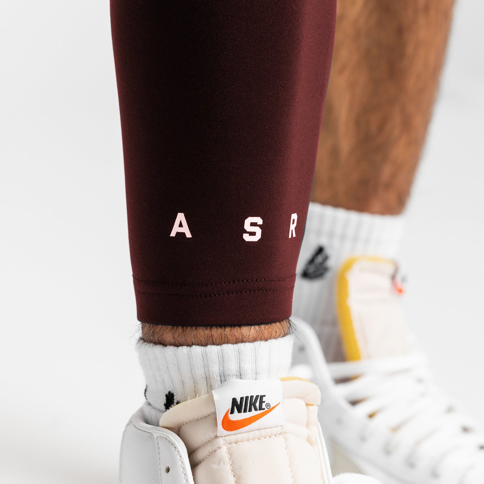 WarpFlexx® Leg Sleeve in crimson worn with white socks and white sneakers, detail view