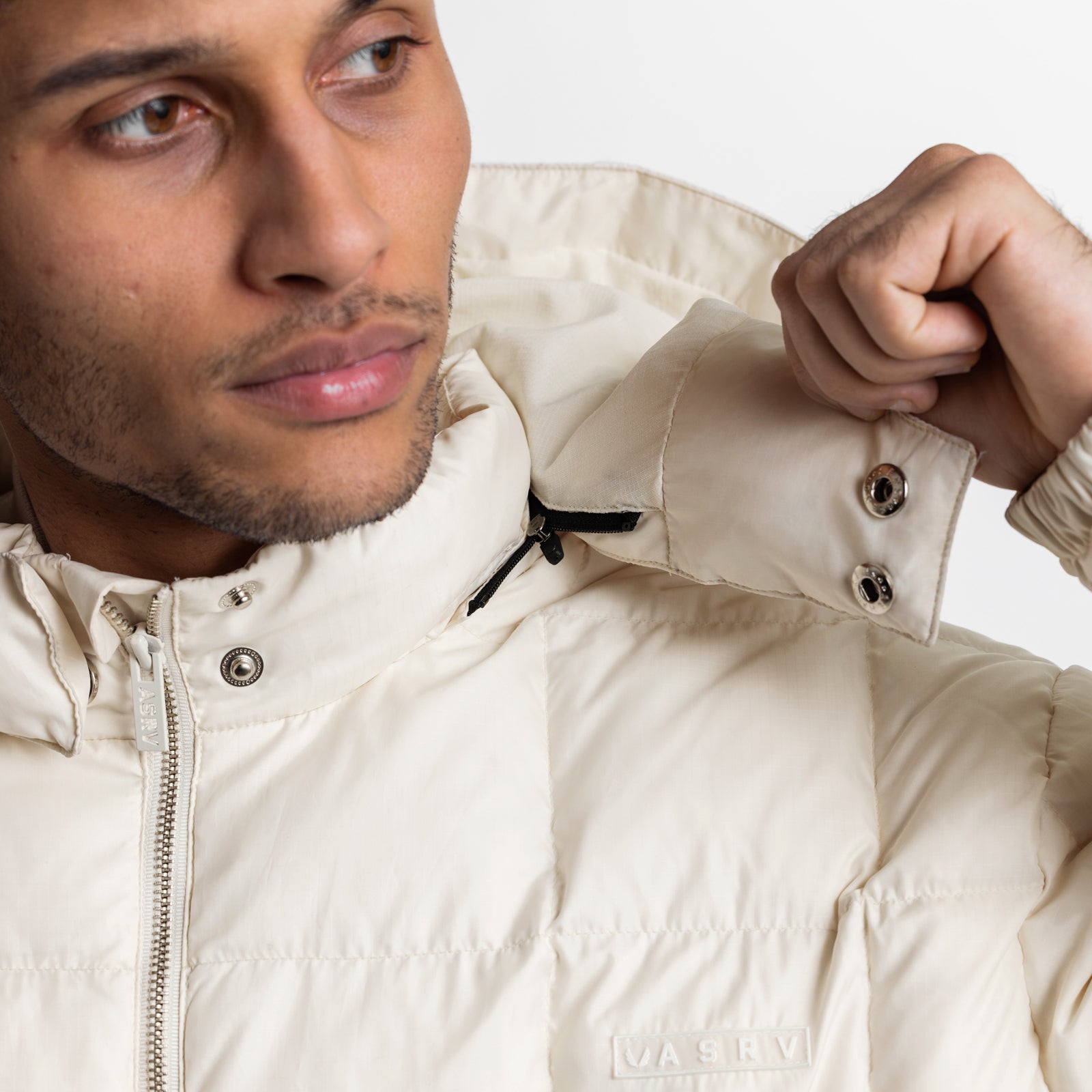 Weather-Ready Down Puffer Jacket in ivory cream, worn by model with hand adjusting collar