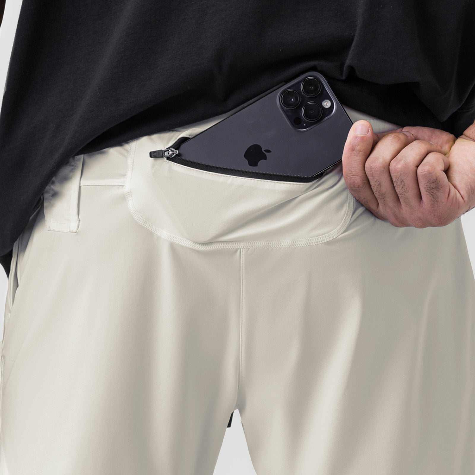 Tetra-Lite 7" Liner Short in Stone, worn with model holding iPhone in pocket