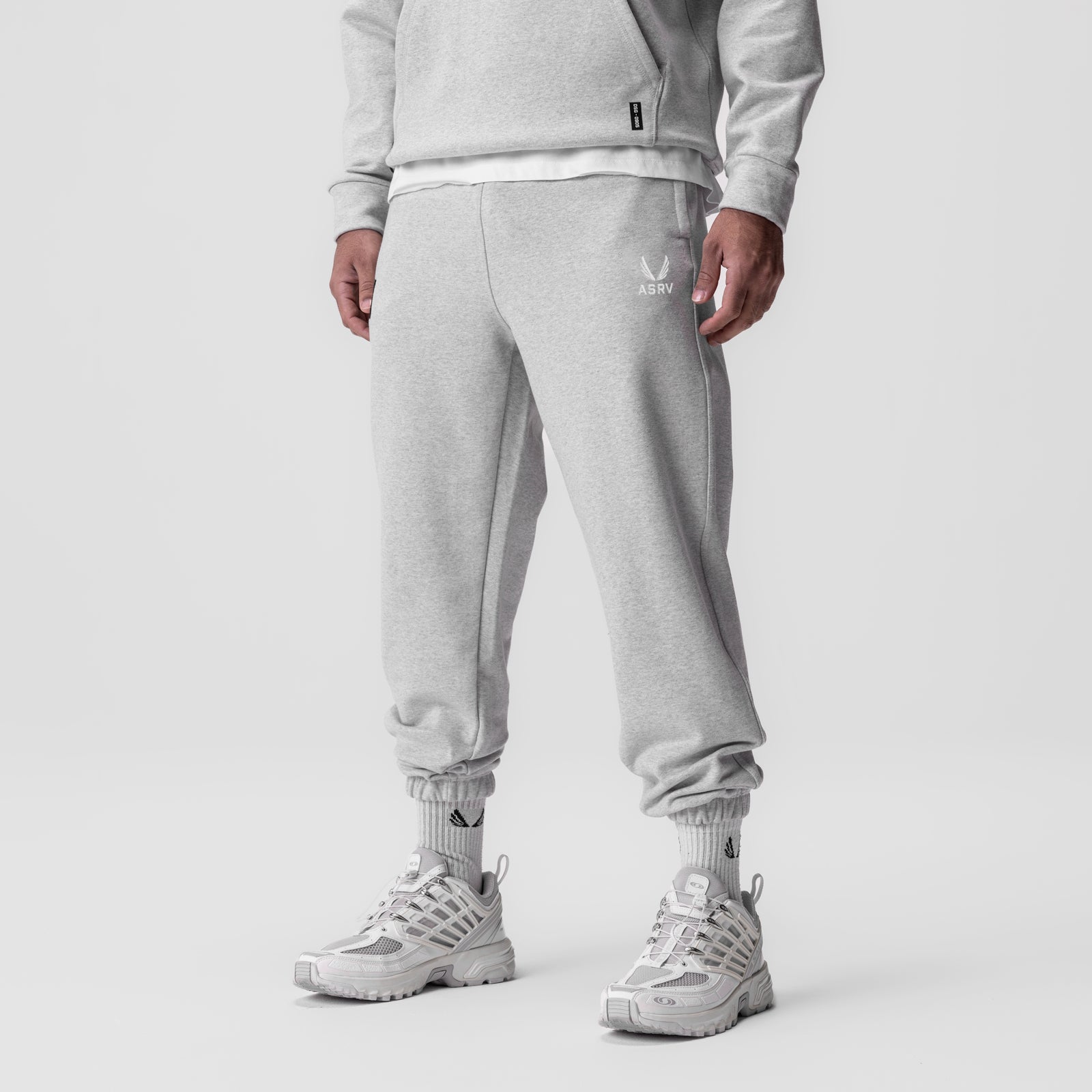 Heather grey tech-terry oversized sweatpants on model, full-length front view with sneakers
