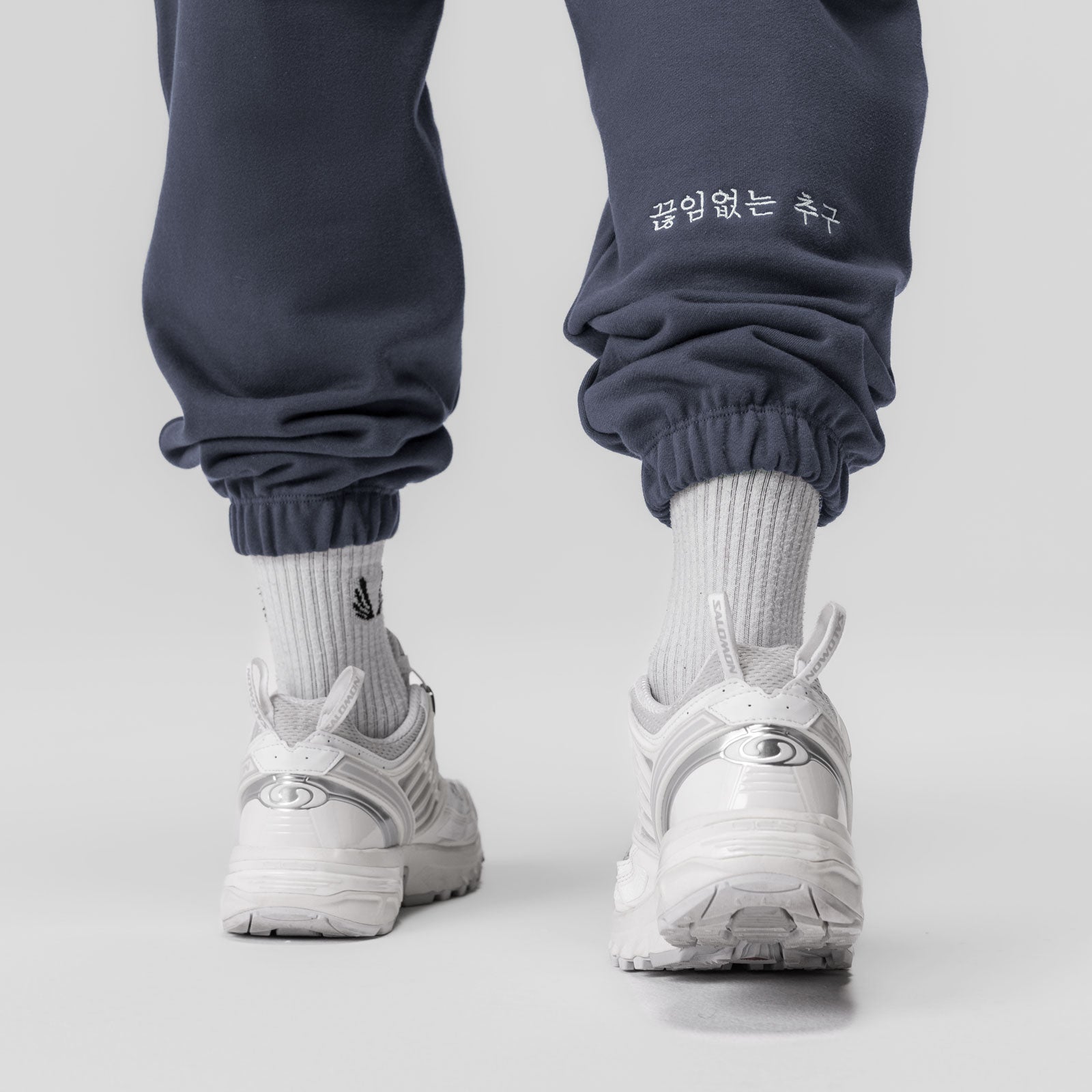 Navy Tech-Terry oversized sweatpants styled with white socks and sneakers, back view
