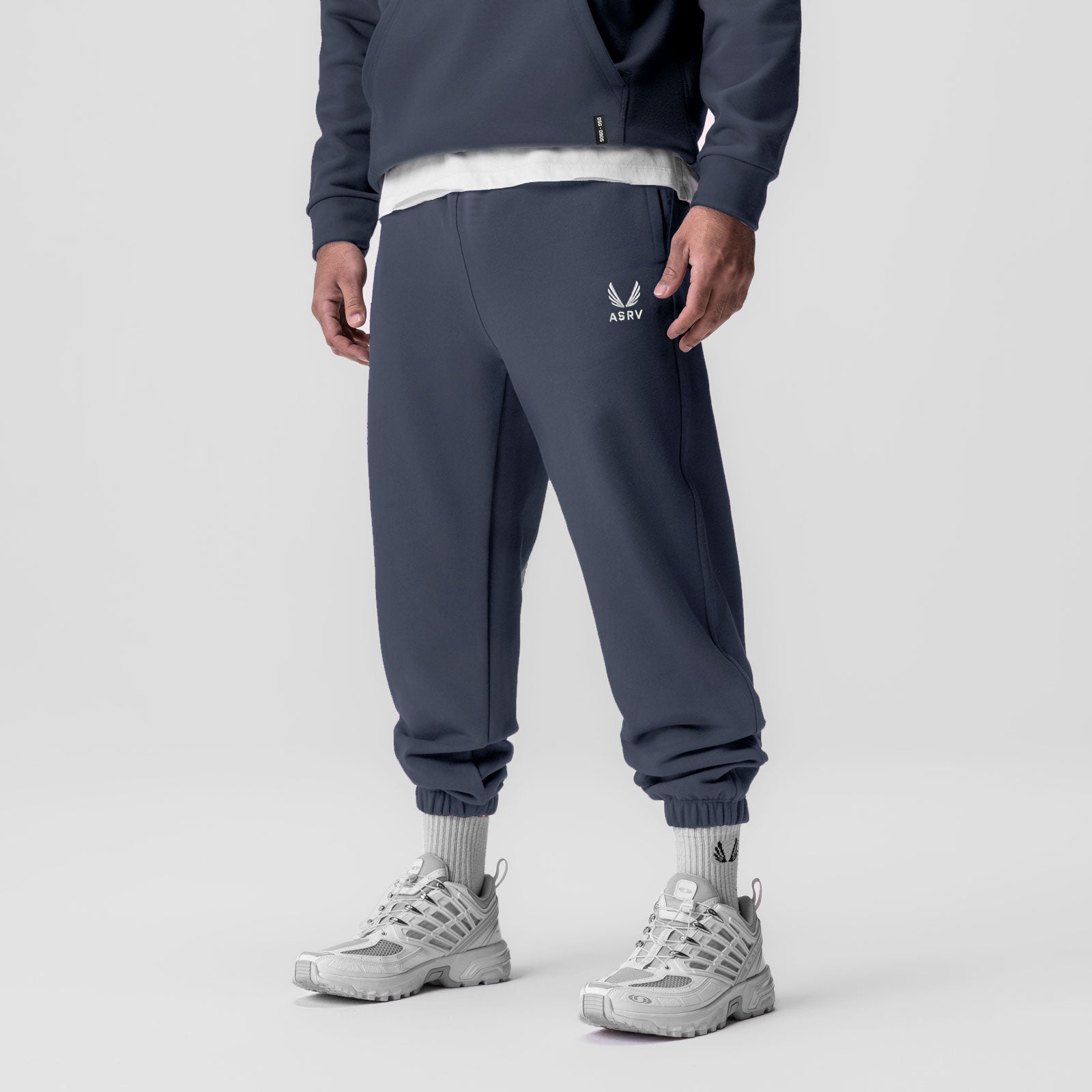 Tech-Terry Oversized Sweats in navy with emblem logo, worn by model with white sneakers