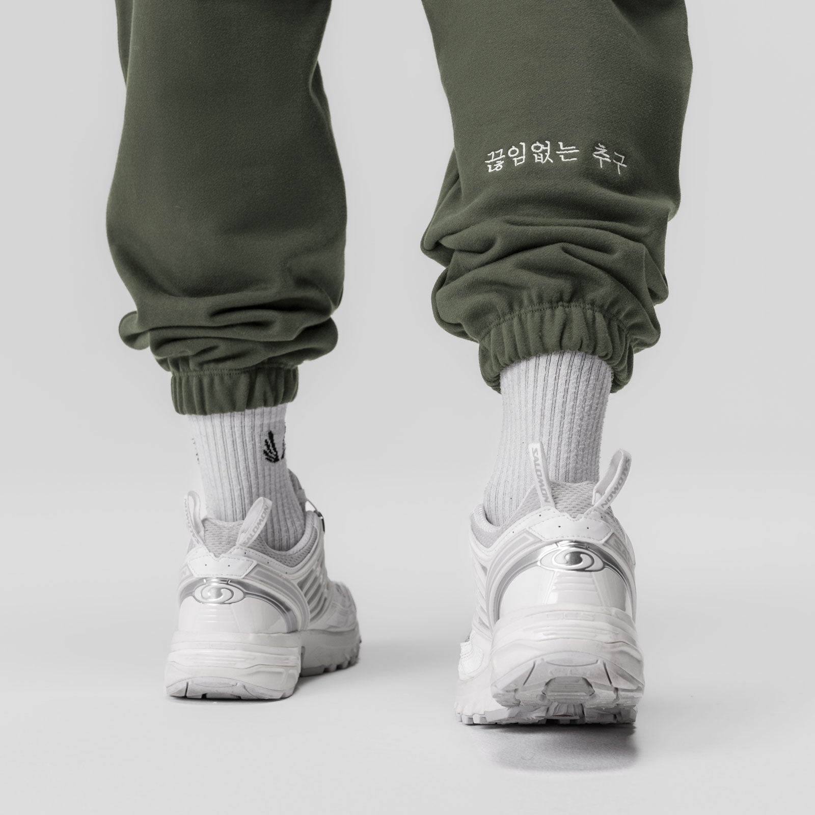 Tech-Terry Oversized Sweats in olive worn with white socks and sneakers, back view