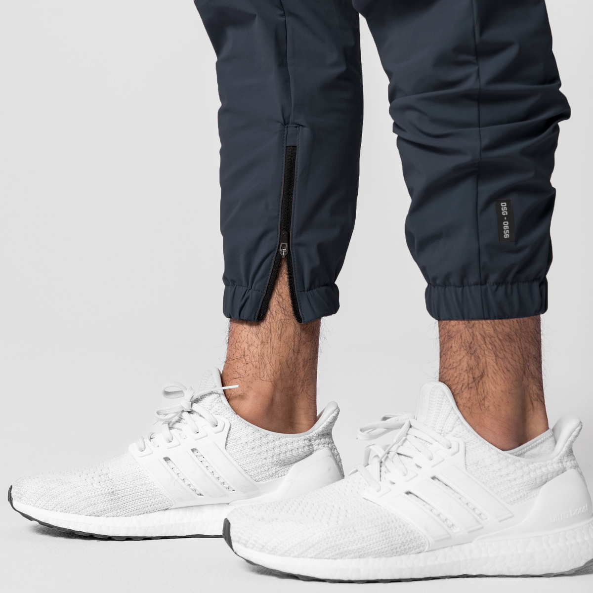 Navy Tetra-Lite Standard Zip Jogger worn with white sneakers, cropped view of legs and feet