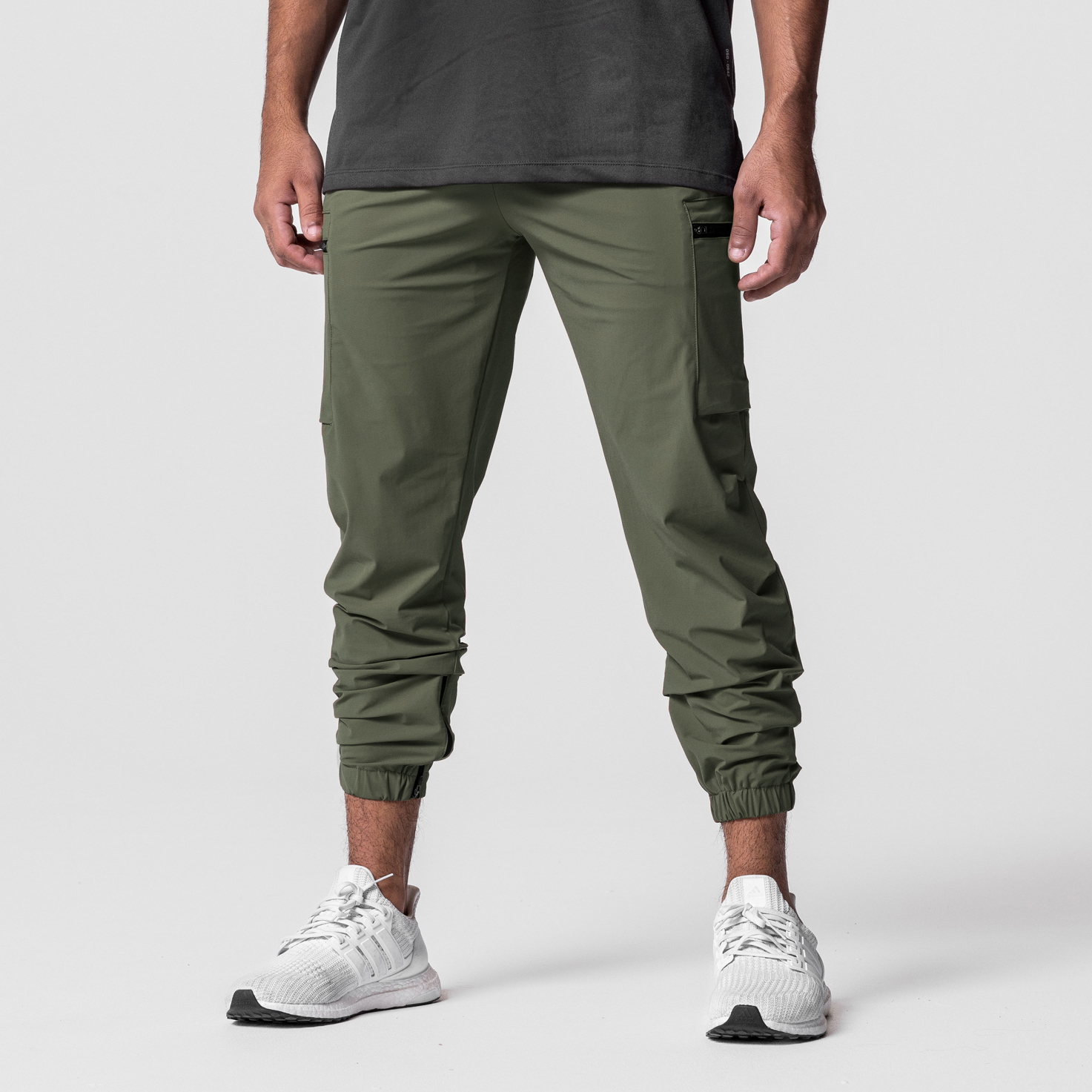 Tetra-Lite Standard Zip Jogger in olive, worn by model with white sneakers, front view